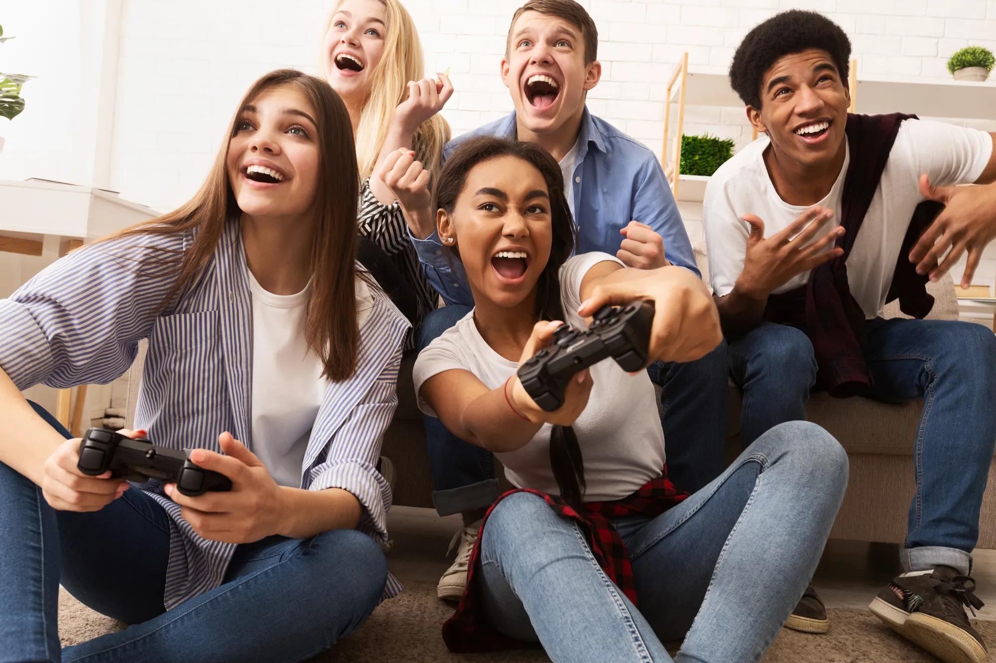 Teens playing video games in new home gameroom