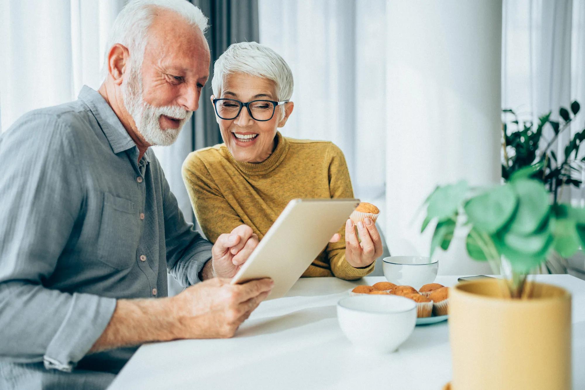 Couple enjoying technology in their new home kitchen