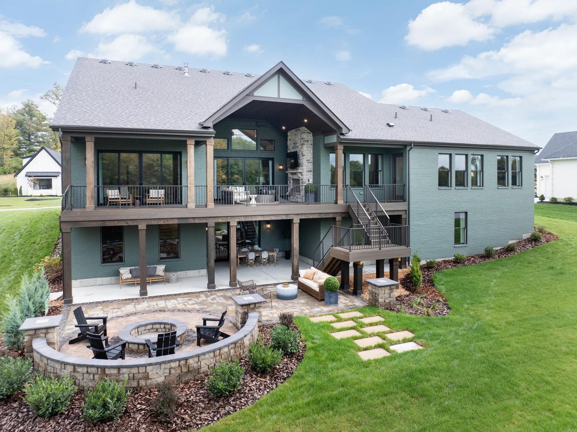 Custom home backyard with second story porch, covered patio and outdoor firepit 