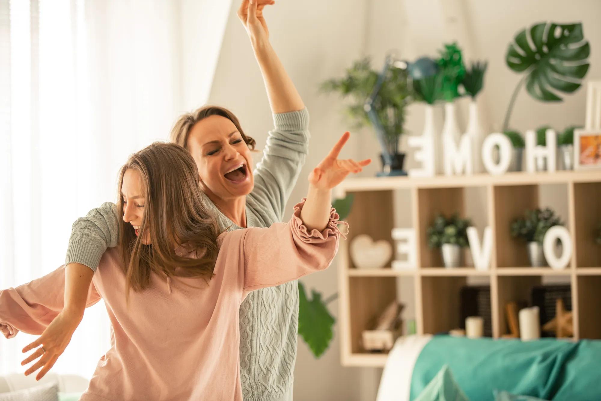 Family dancing in their new home living room