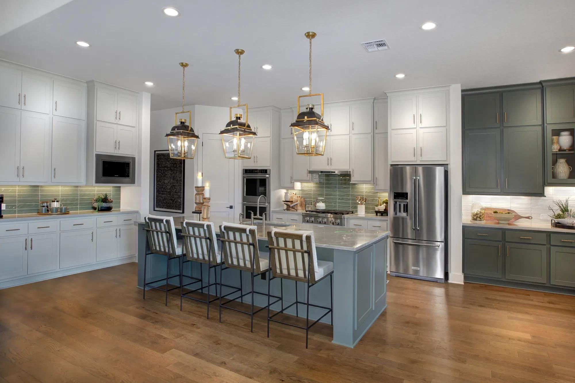 Bright kitchen with double ovens, expansive island, and custom storage in a new Drees custom home