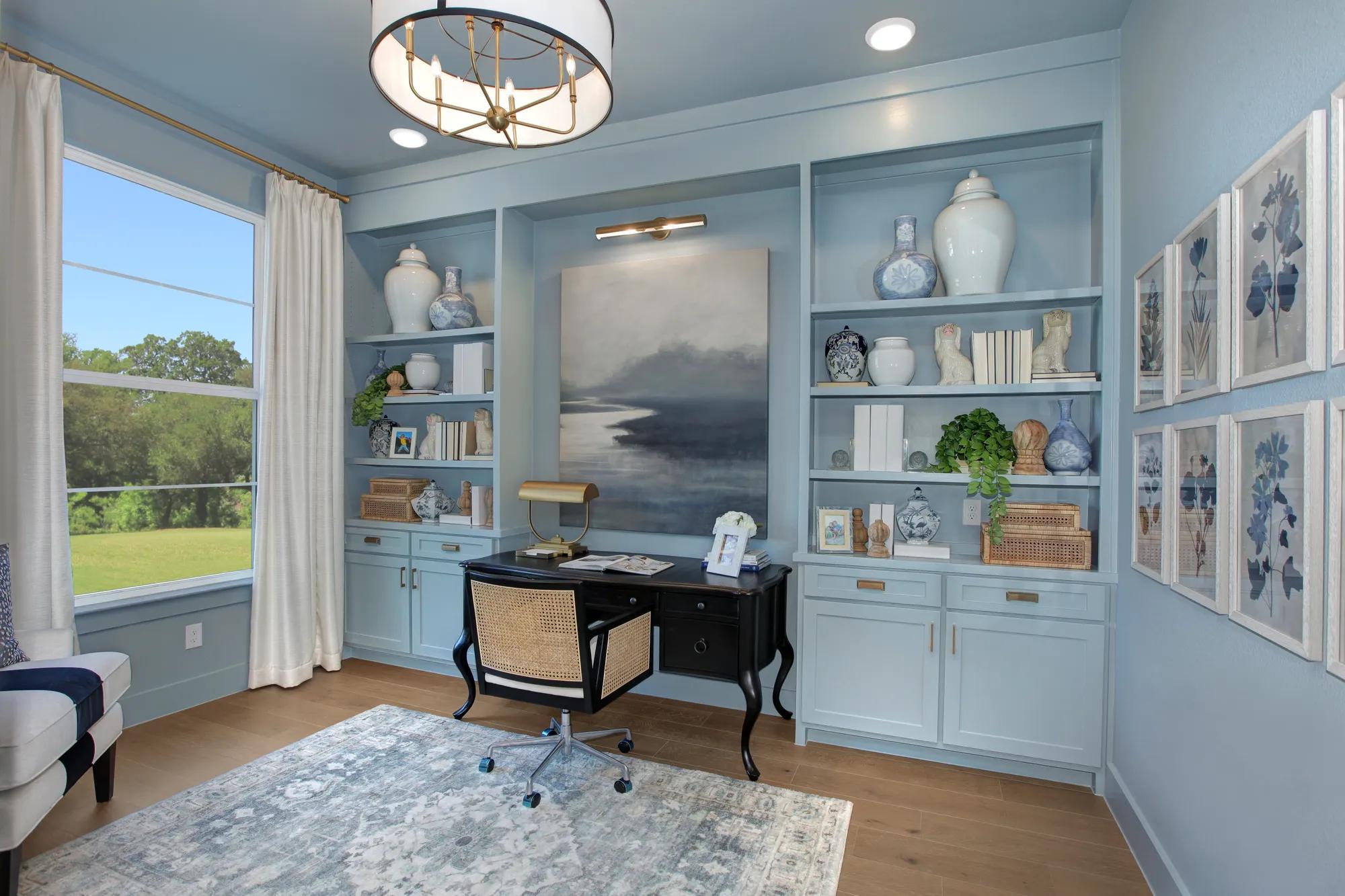 Custom home office with light blue color drenched walls, ceiling, built in shelves