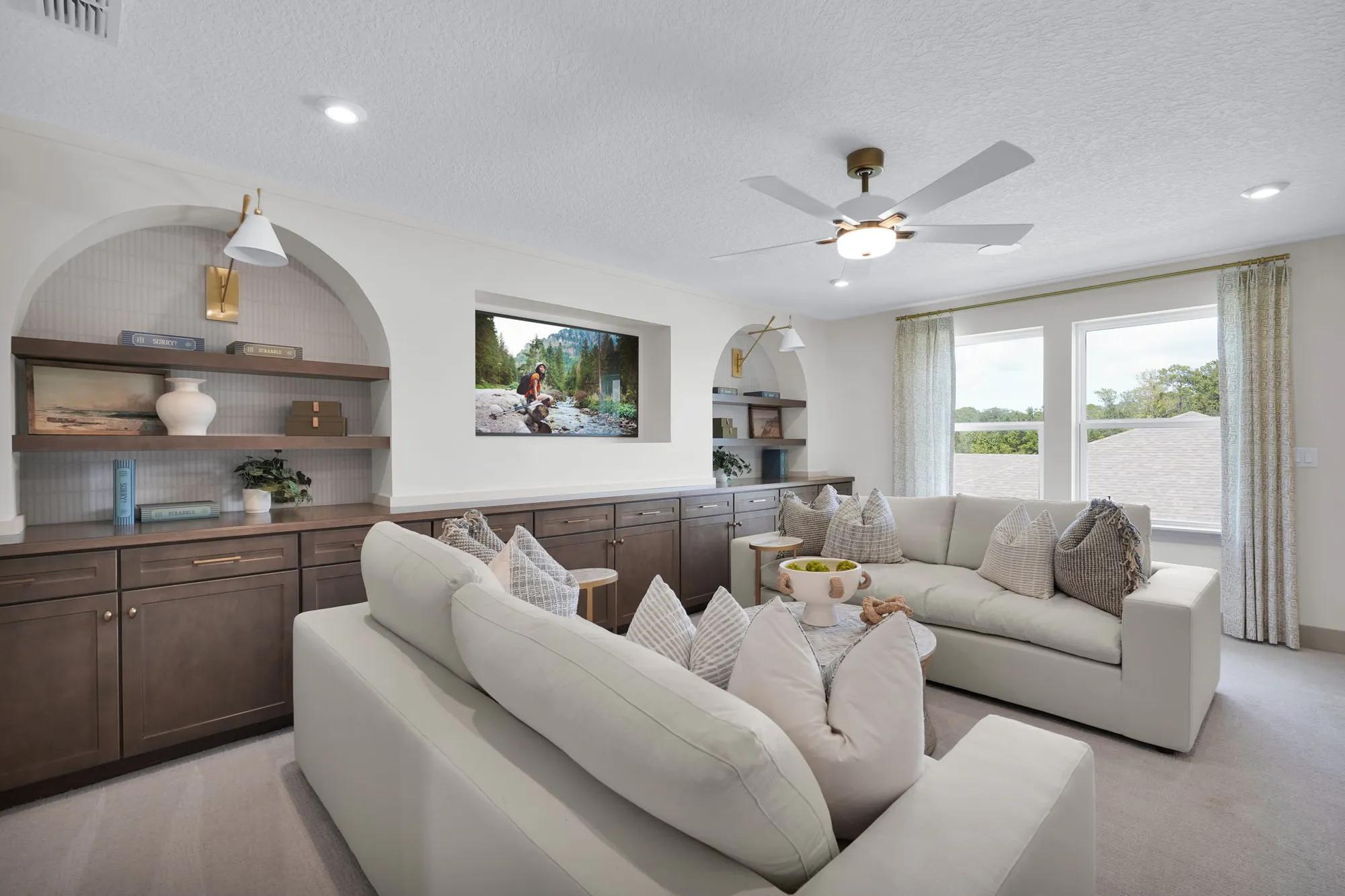 New home gameroom with built in wood cabinet storage and wall arches