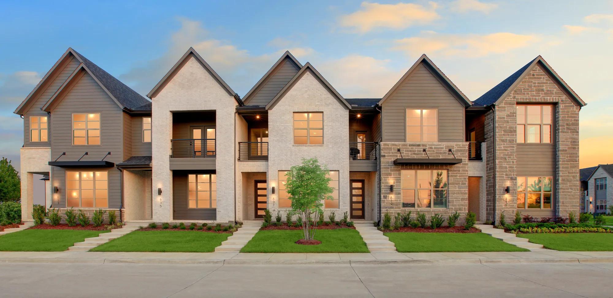 New construction townhome exterior with landscaping at sunset