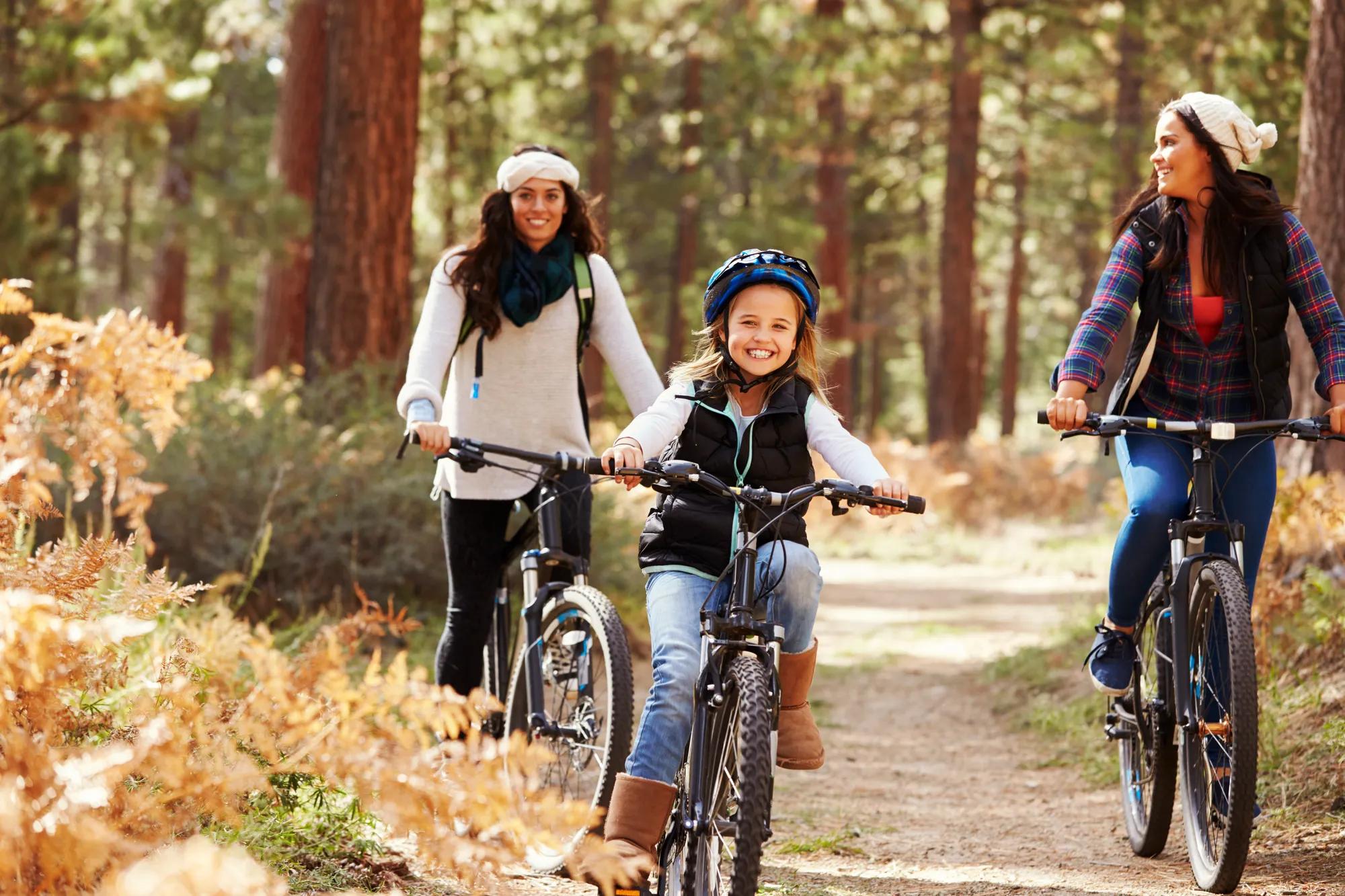 Daughter and moms biking on forest trail