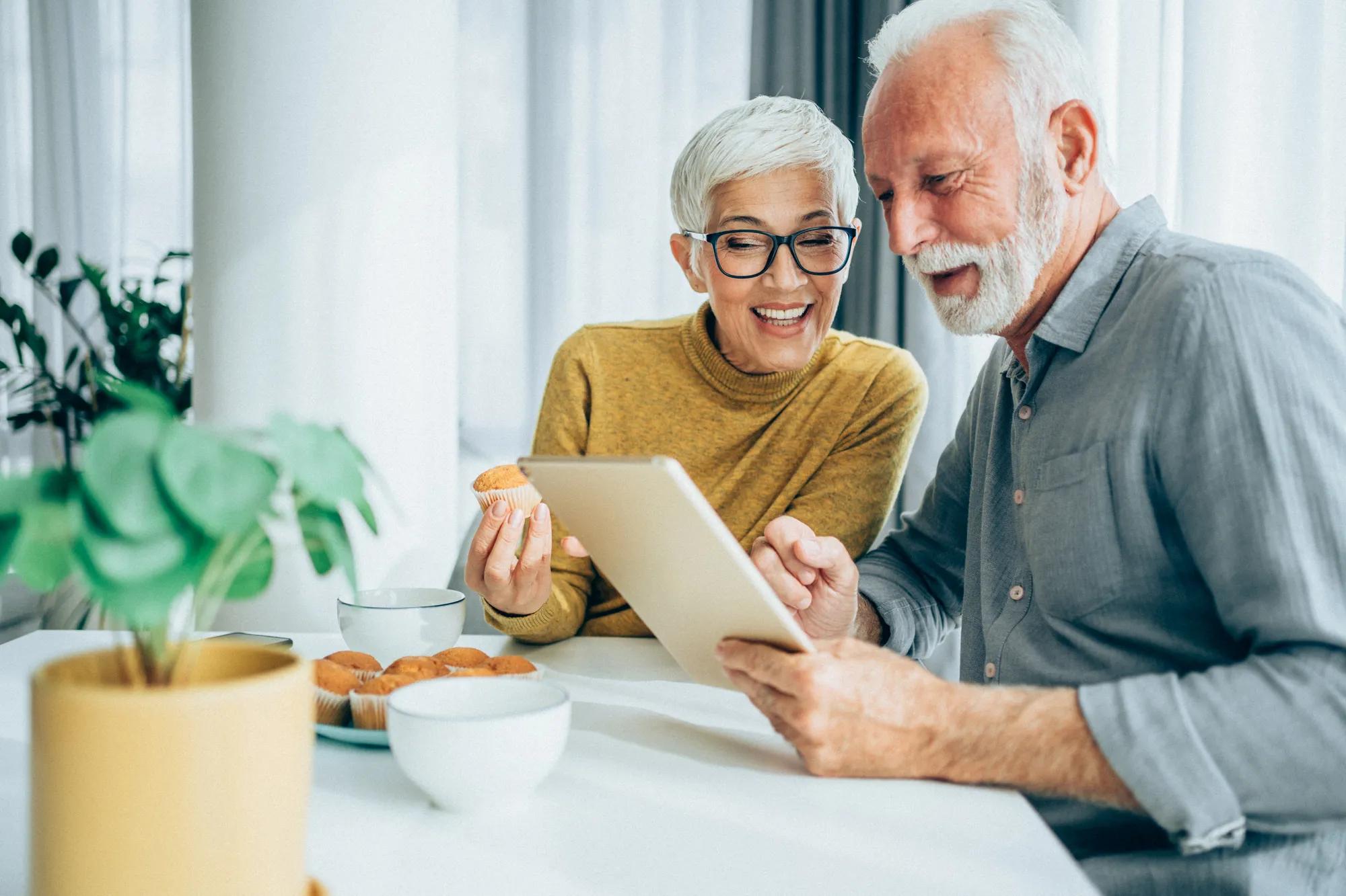 Couple enjoying technology in new home kitchen