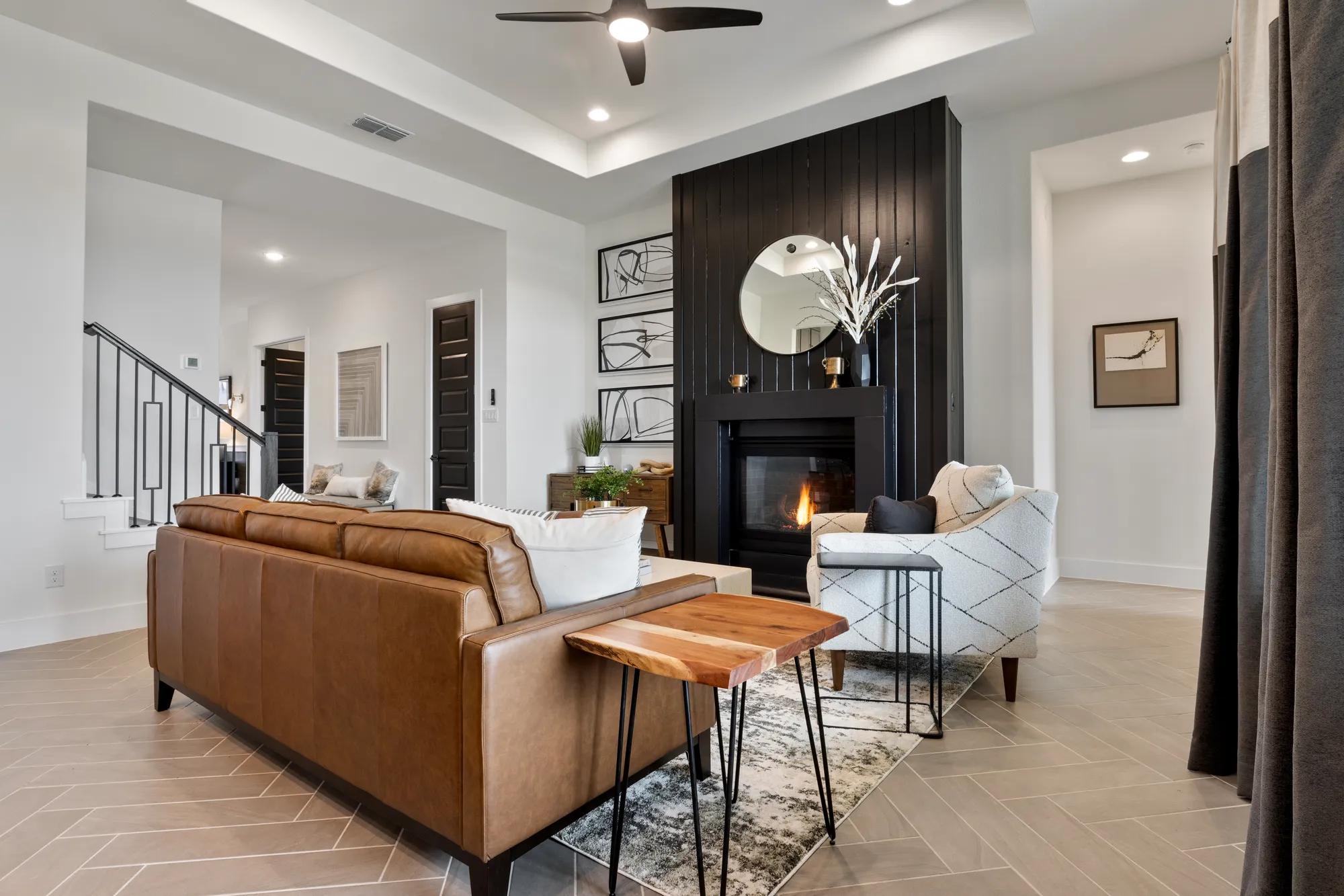 Custom home family room with black fireplace and tile floor