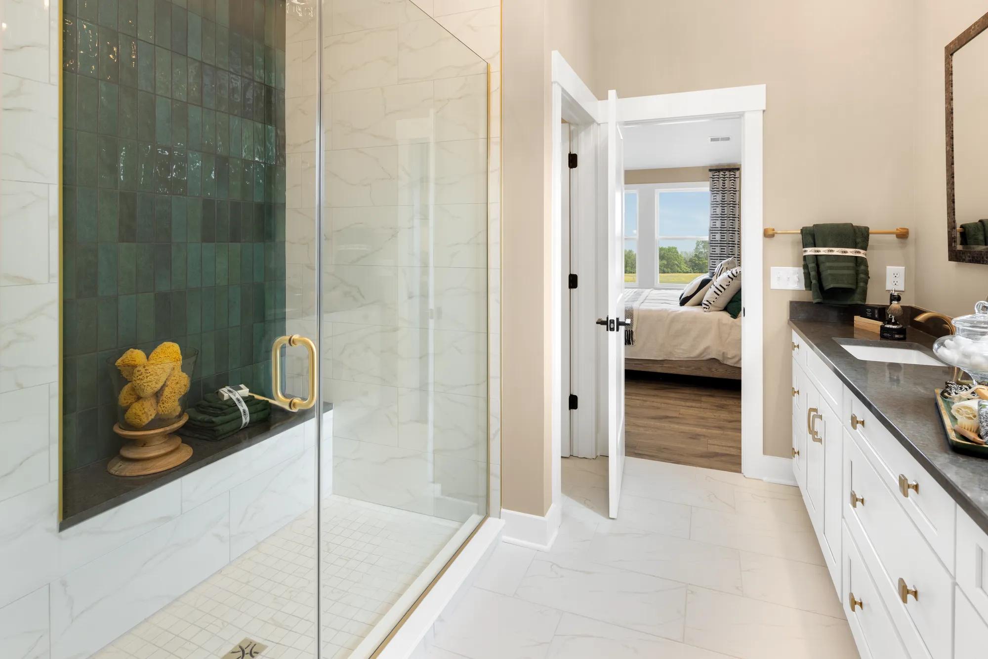 primary bath with glass shower and double vanities