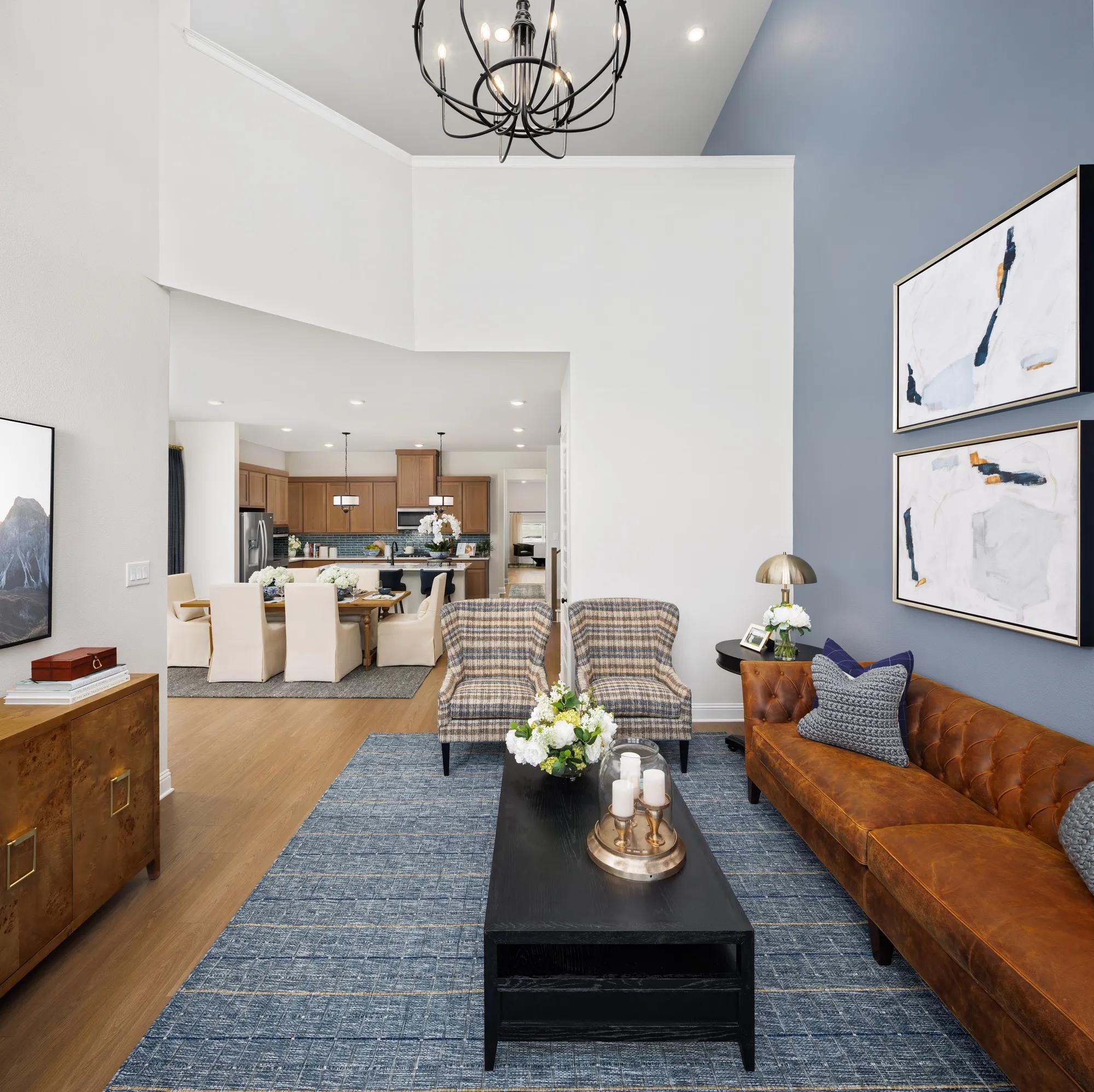 New construction townhome two-story family room with blue accent wall and chandelier 