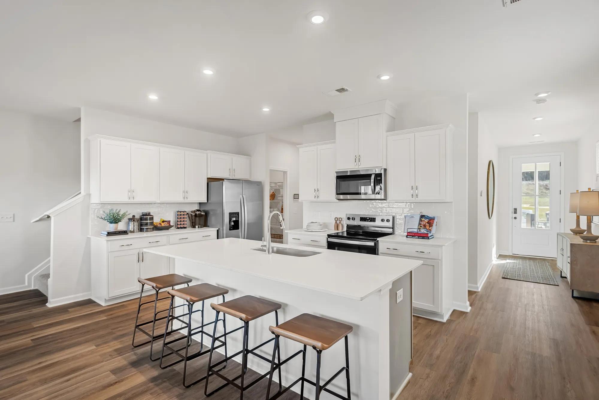 New construction townhome kitchen and foyer with hardwood floors