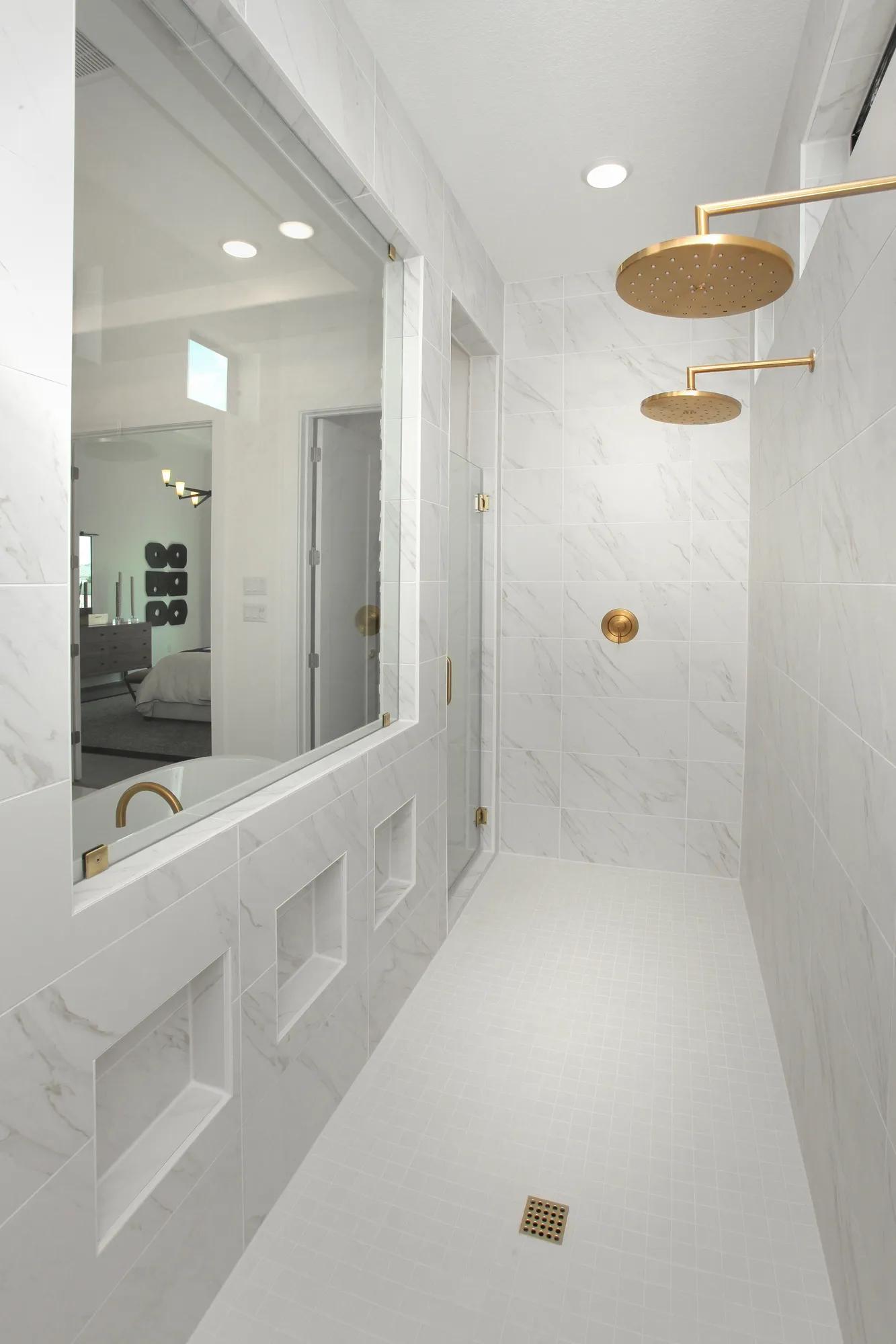 Custom home white marbled tile shower with two gold rain showerheads 