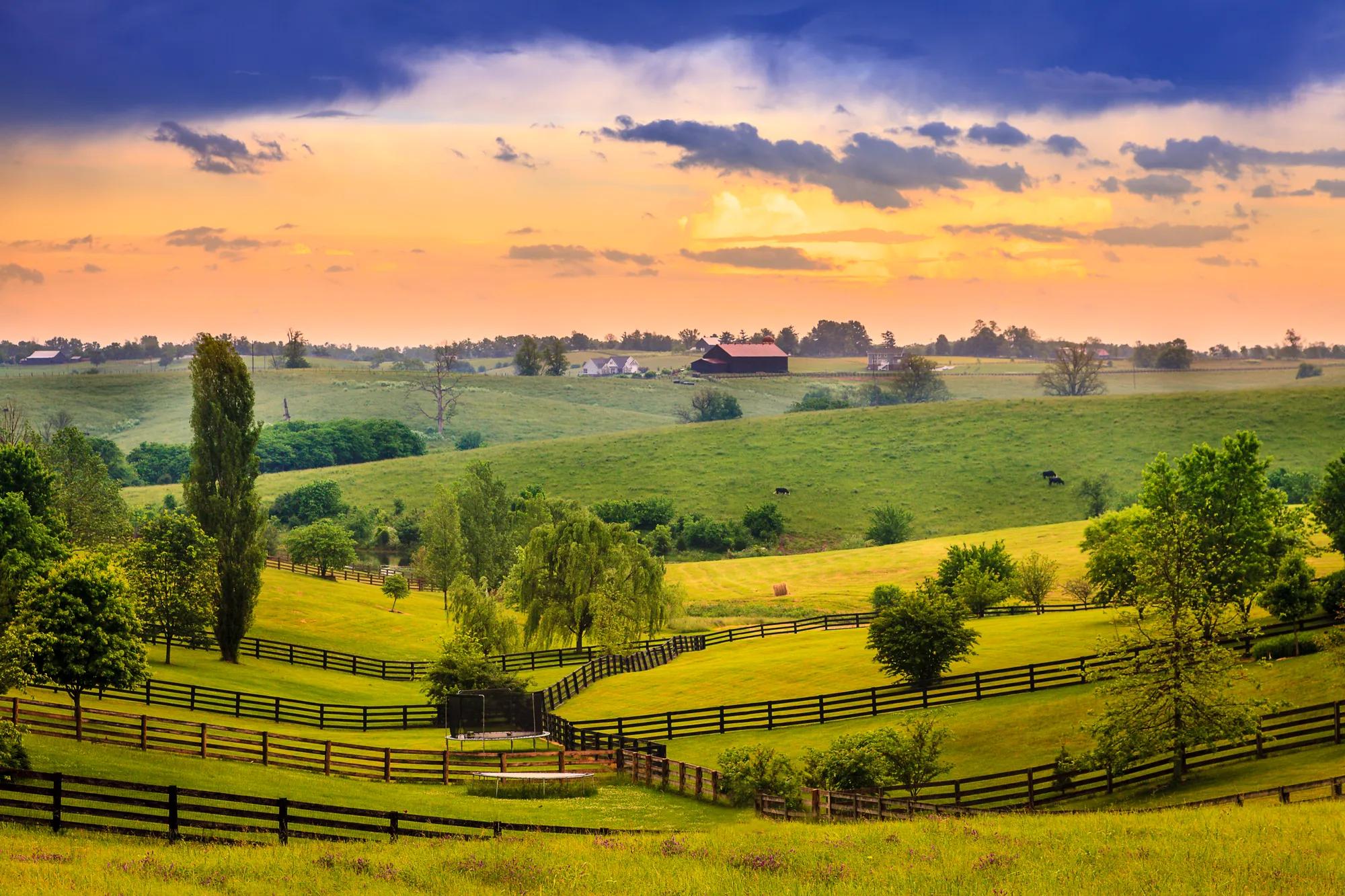Fences and farms in rolling hills of rural Kentucky at sunset