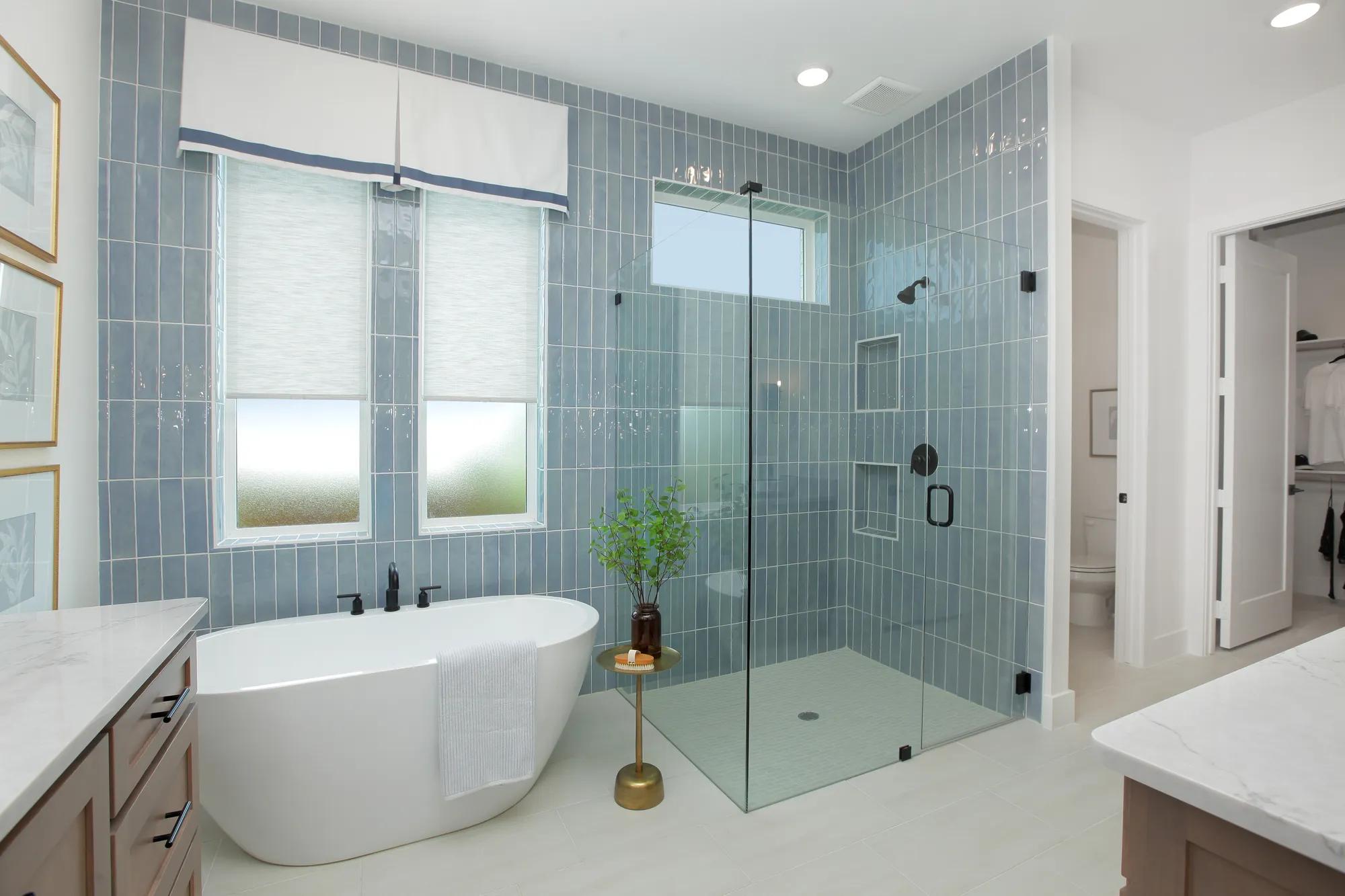 custom primary bathroom with freestanding tub and glass shower