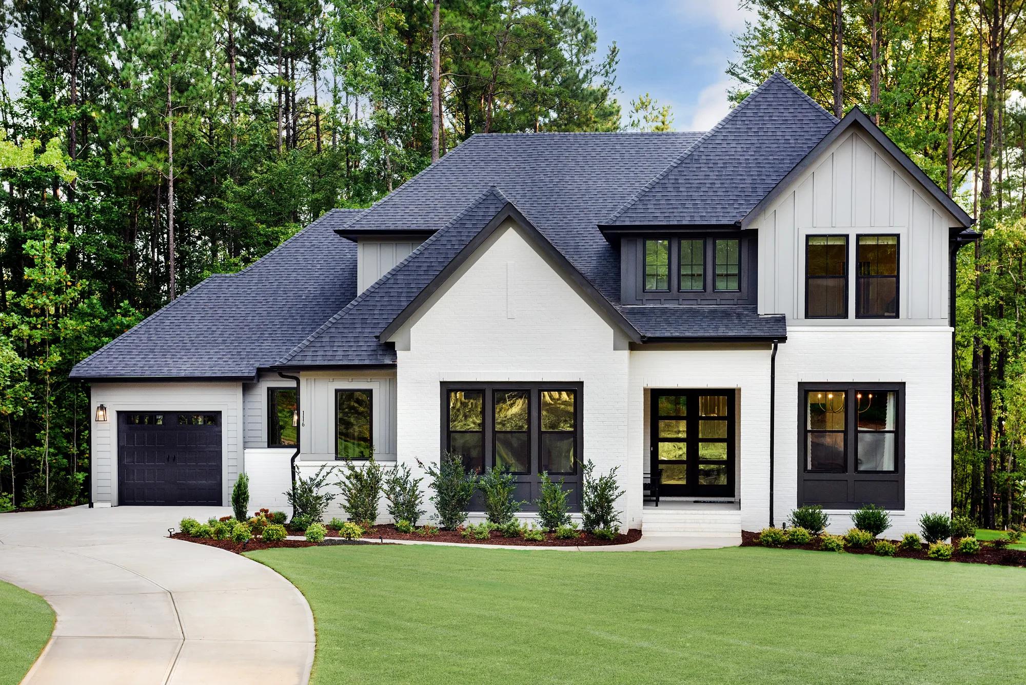 White brick and black frame window custom home with landscaped front yard