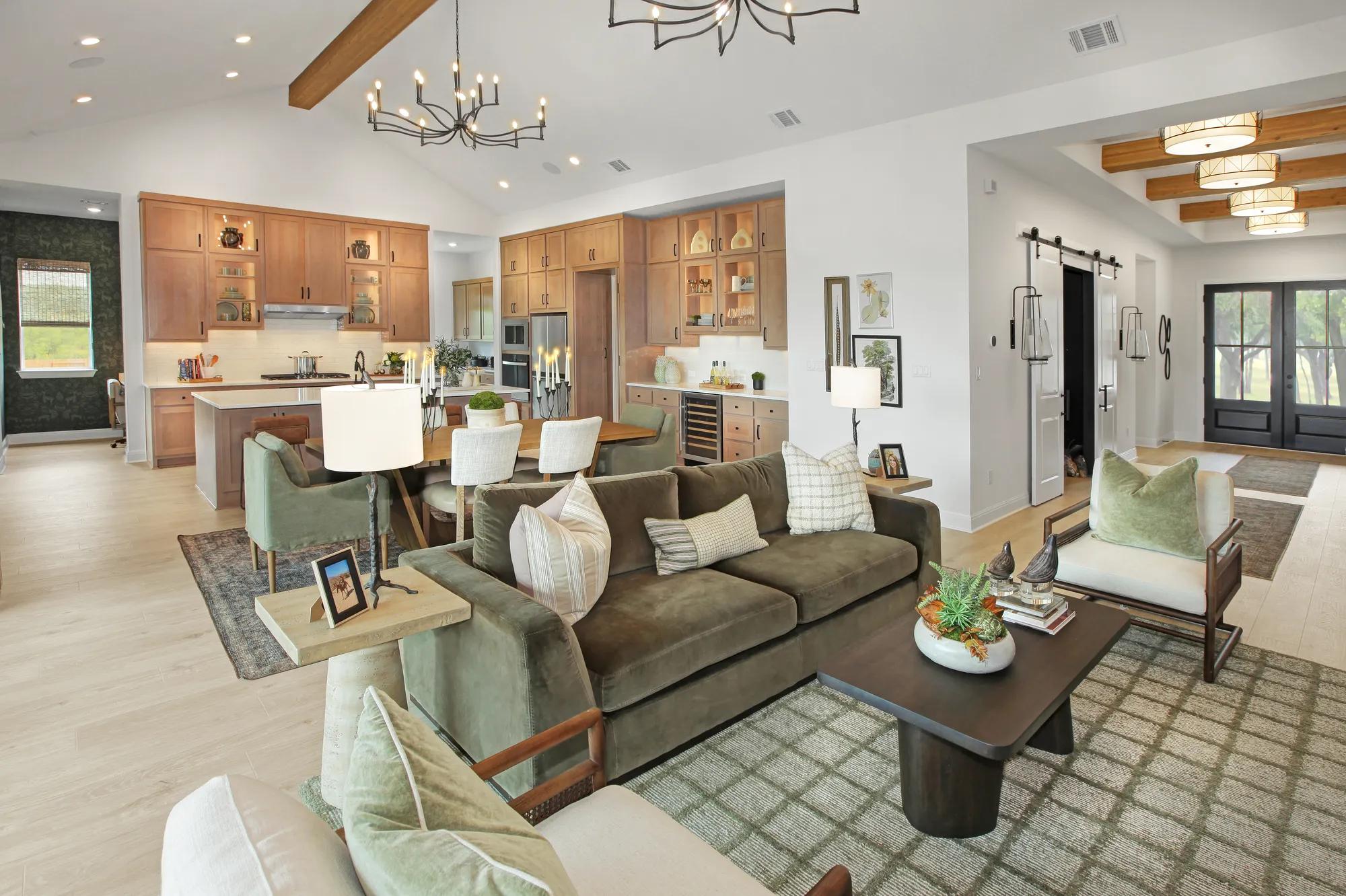 Custom home open floor plan kitchen, dining, family room with sightlines of front door foyer, pocket office, and media room