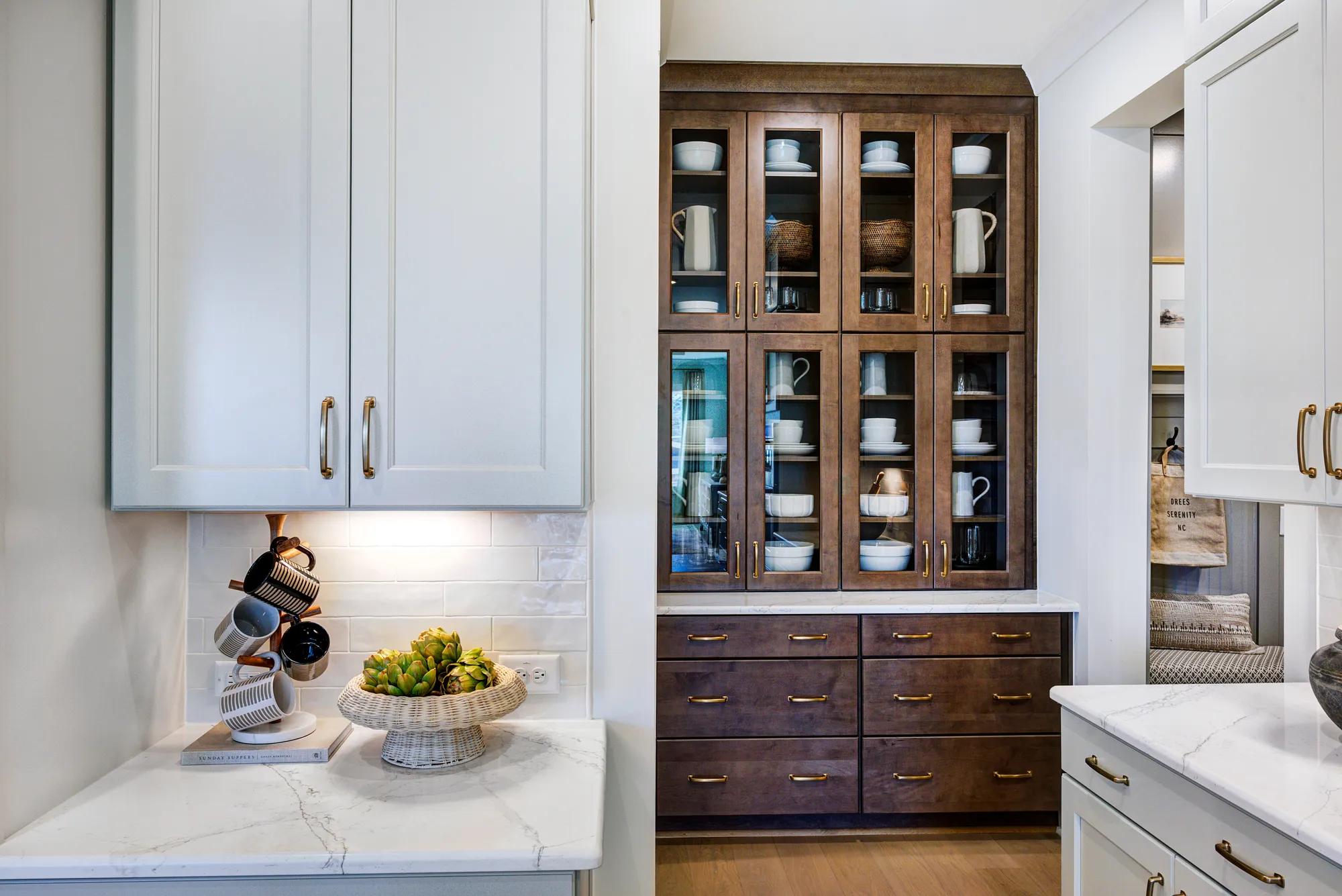 Custom home kitchen with built-in hutch with glass front cabinets and dark wood drawers