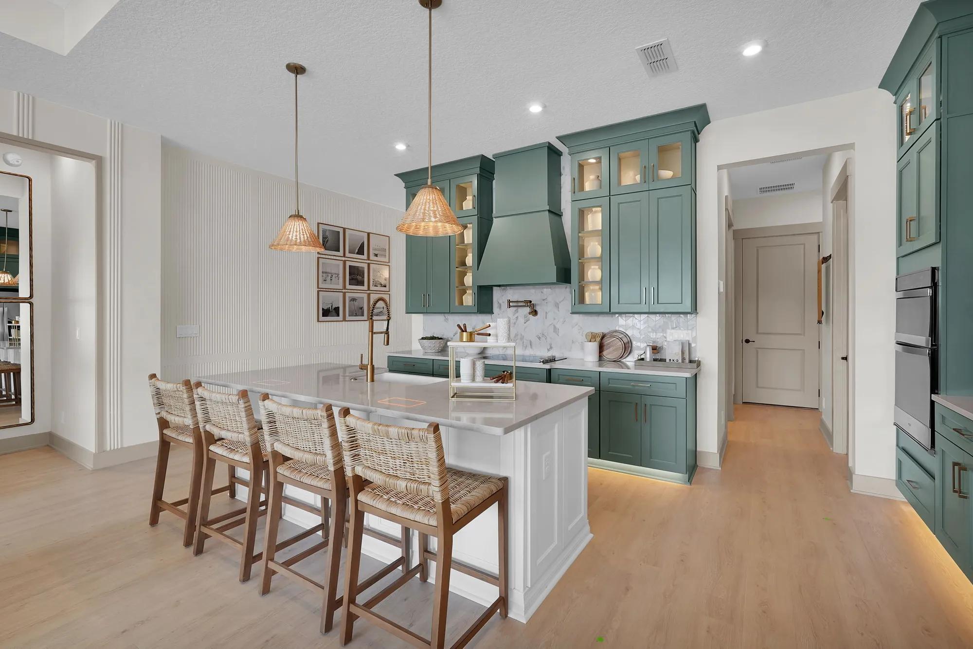 New home kitchen with green painted cabinets and contrasting white kitchen island