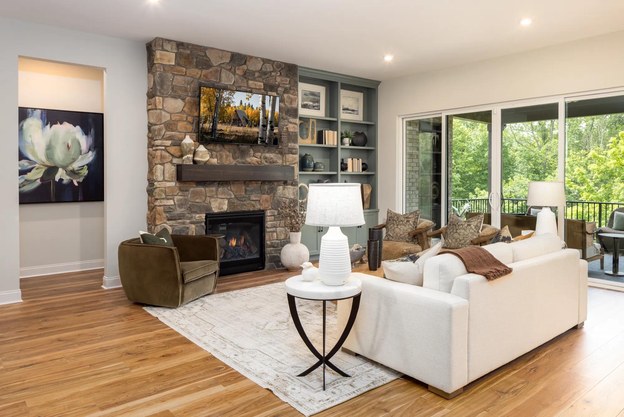Custom home family room with stone fireplace, built-in storage, and sliding glass doors