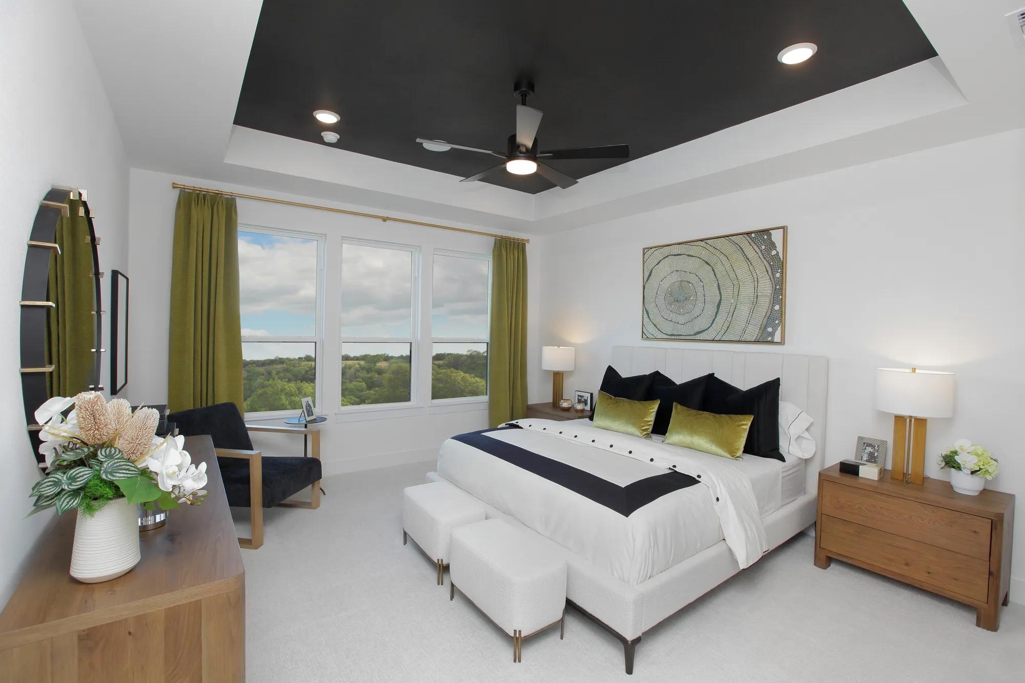 custom home primary bedroom with dark accent ceiling