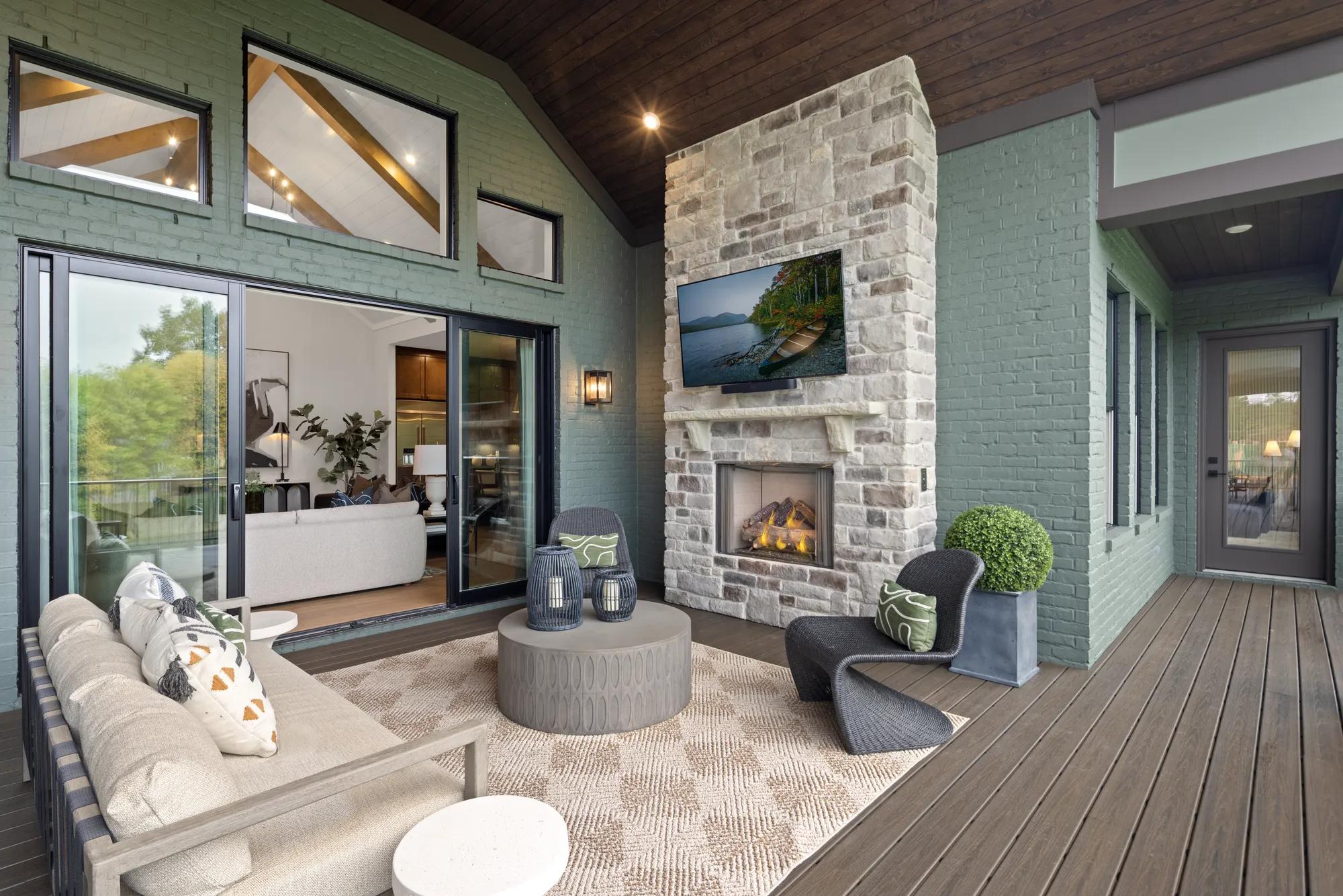 New home covered porch with stone fireplace and TV