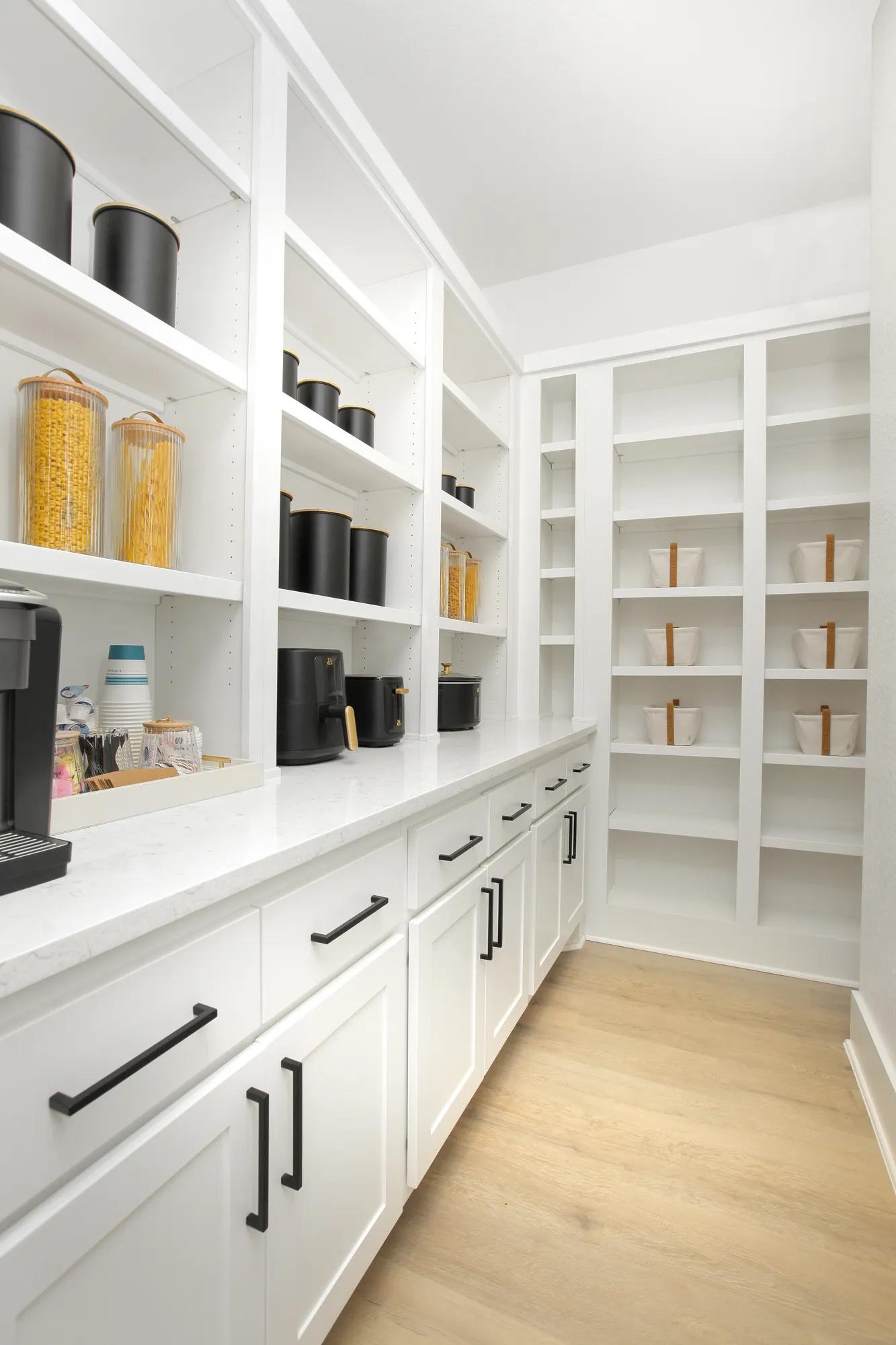 Custom home working pantry with built in countertop and white cabinets
