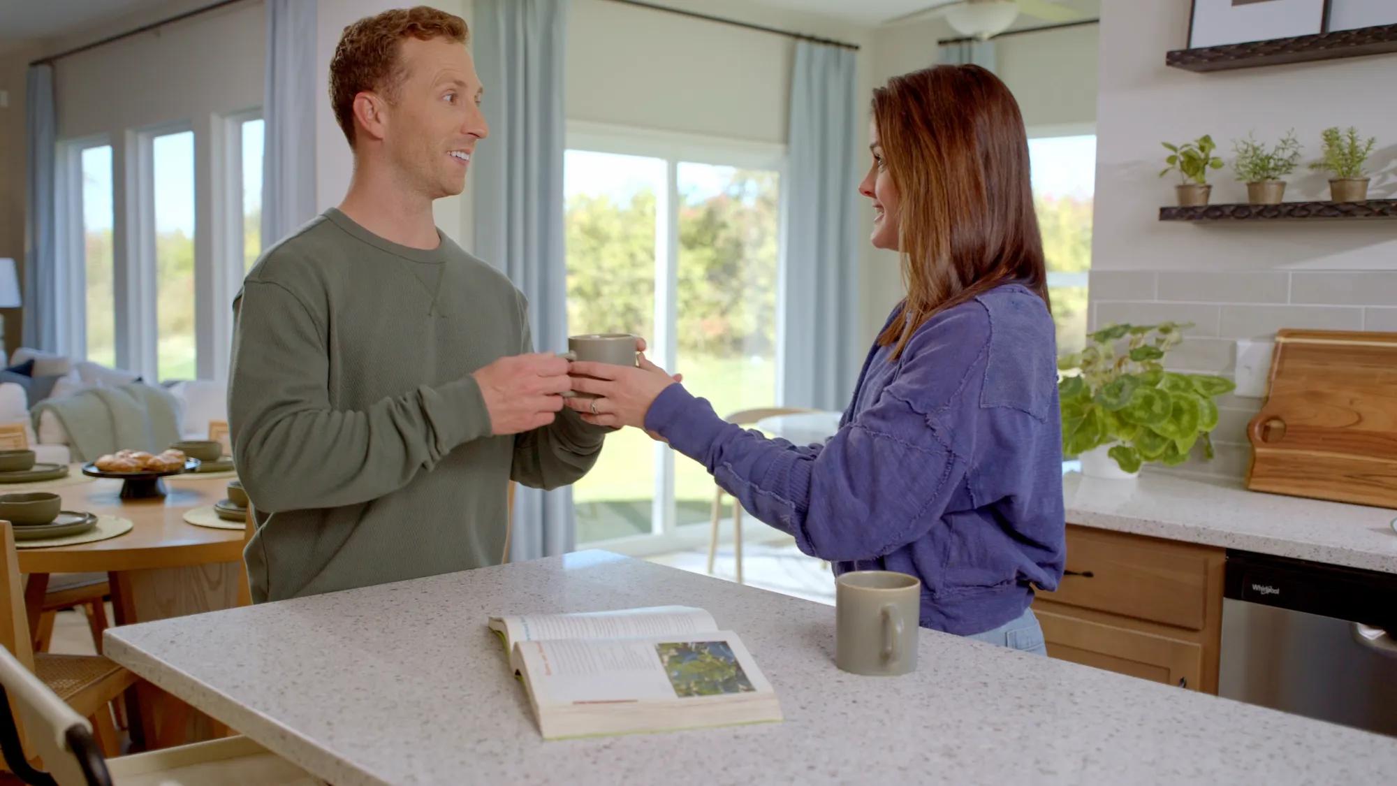 Couple enjoying coffee at kitchen island in new home