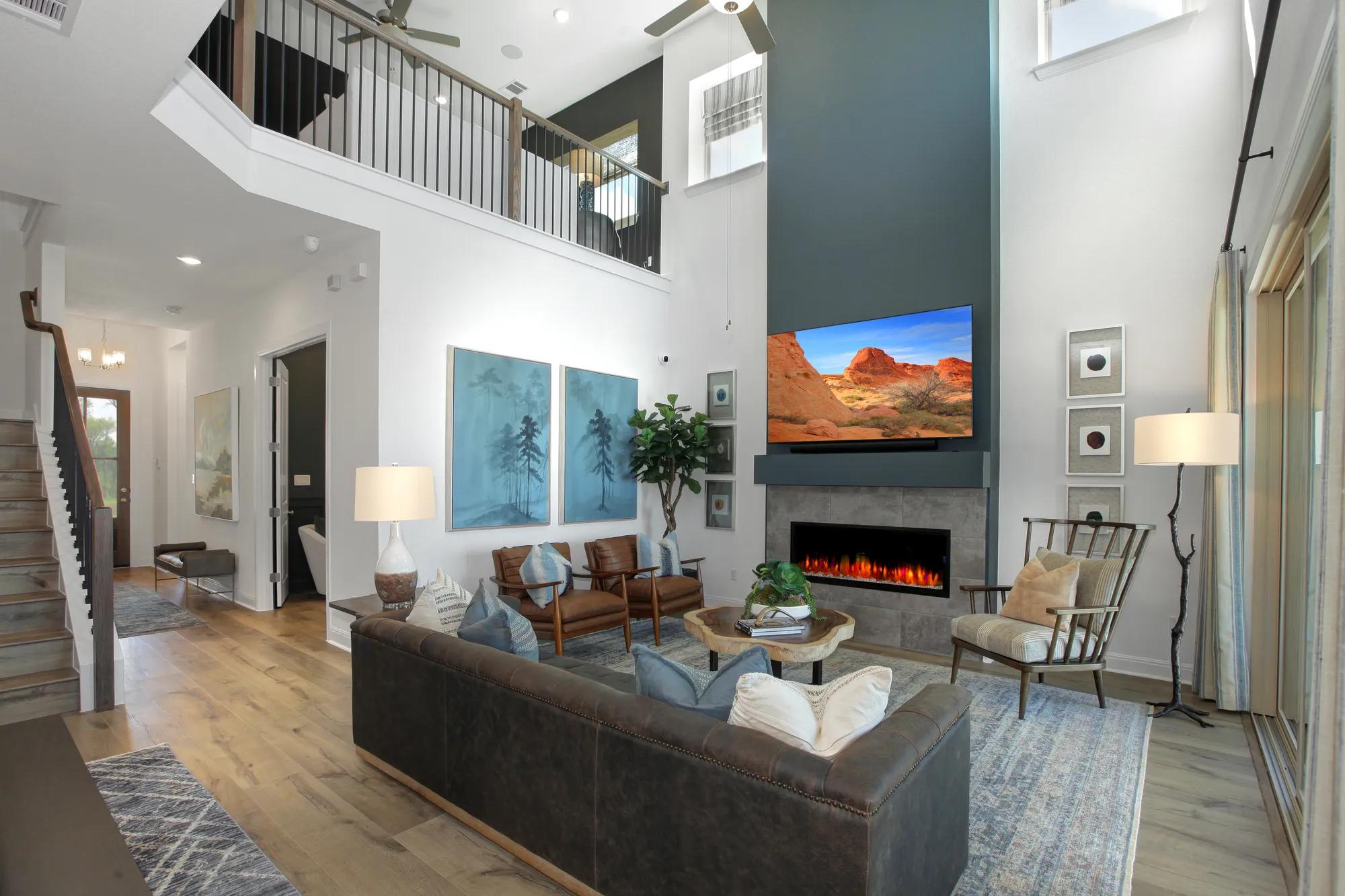 Custom home two-story family room open to upstairs gameroom and centered on blue fireplace