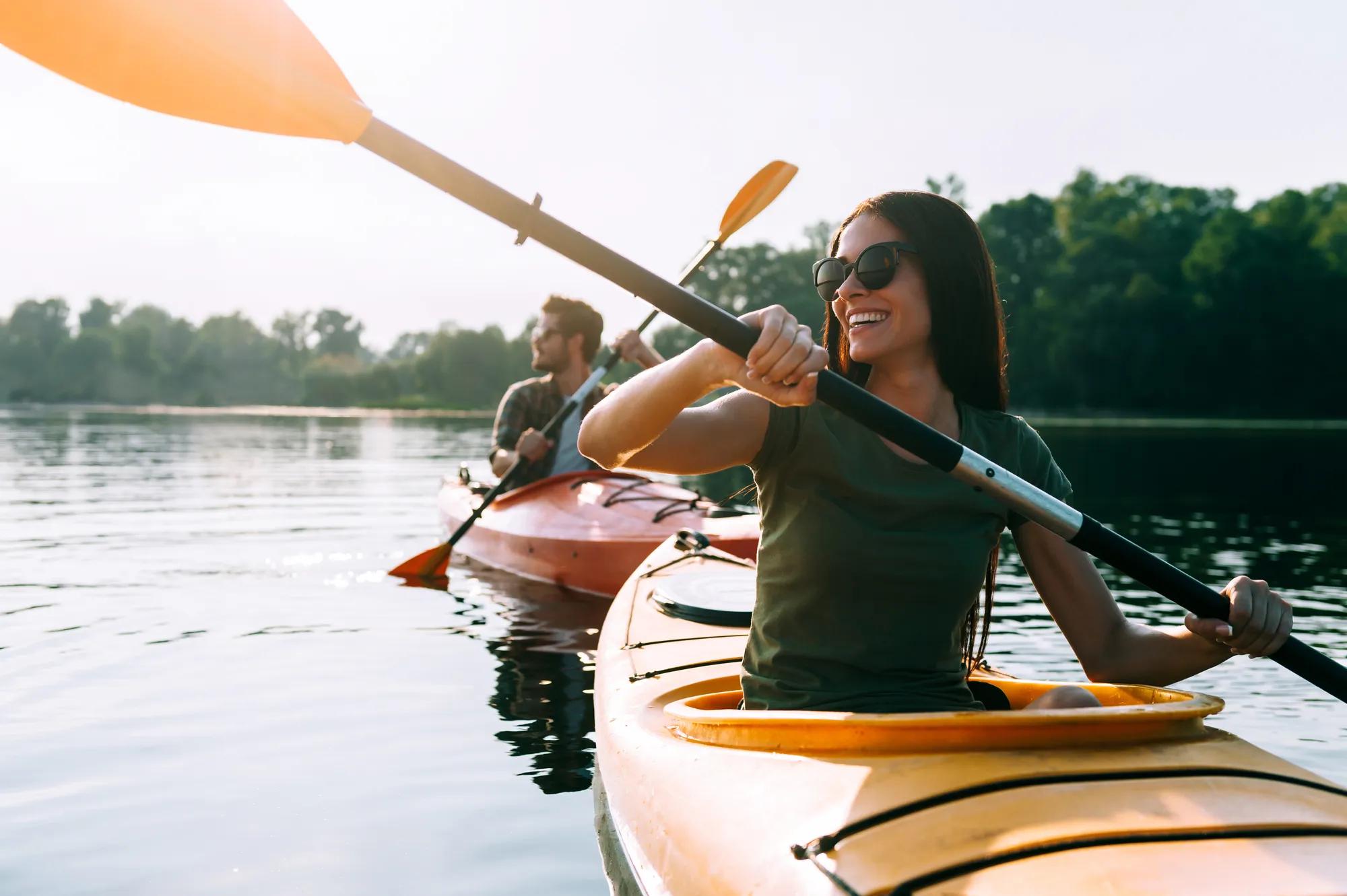 Young couple enjoying kayaking on lake