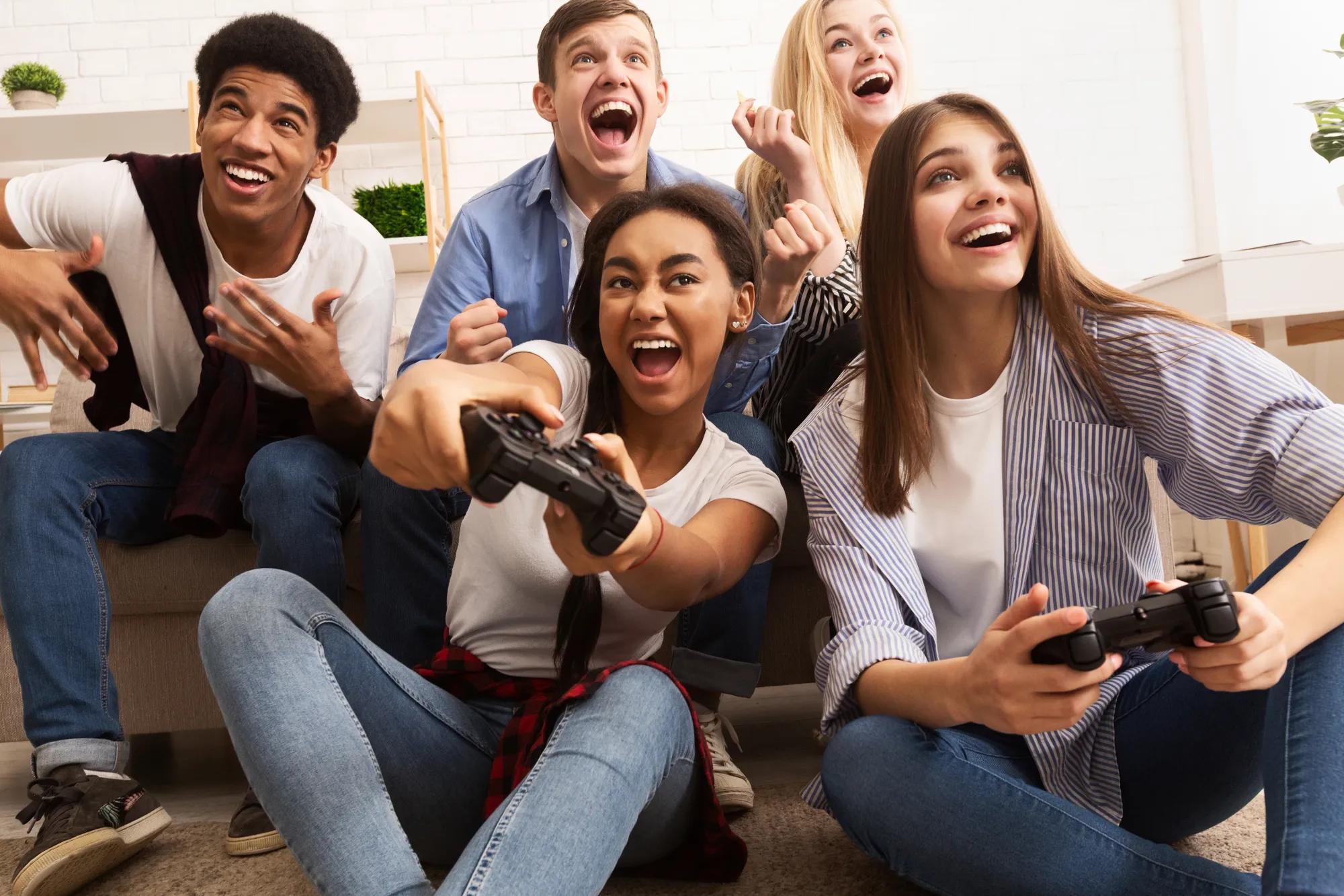 Teens playing video games in family room