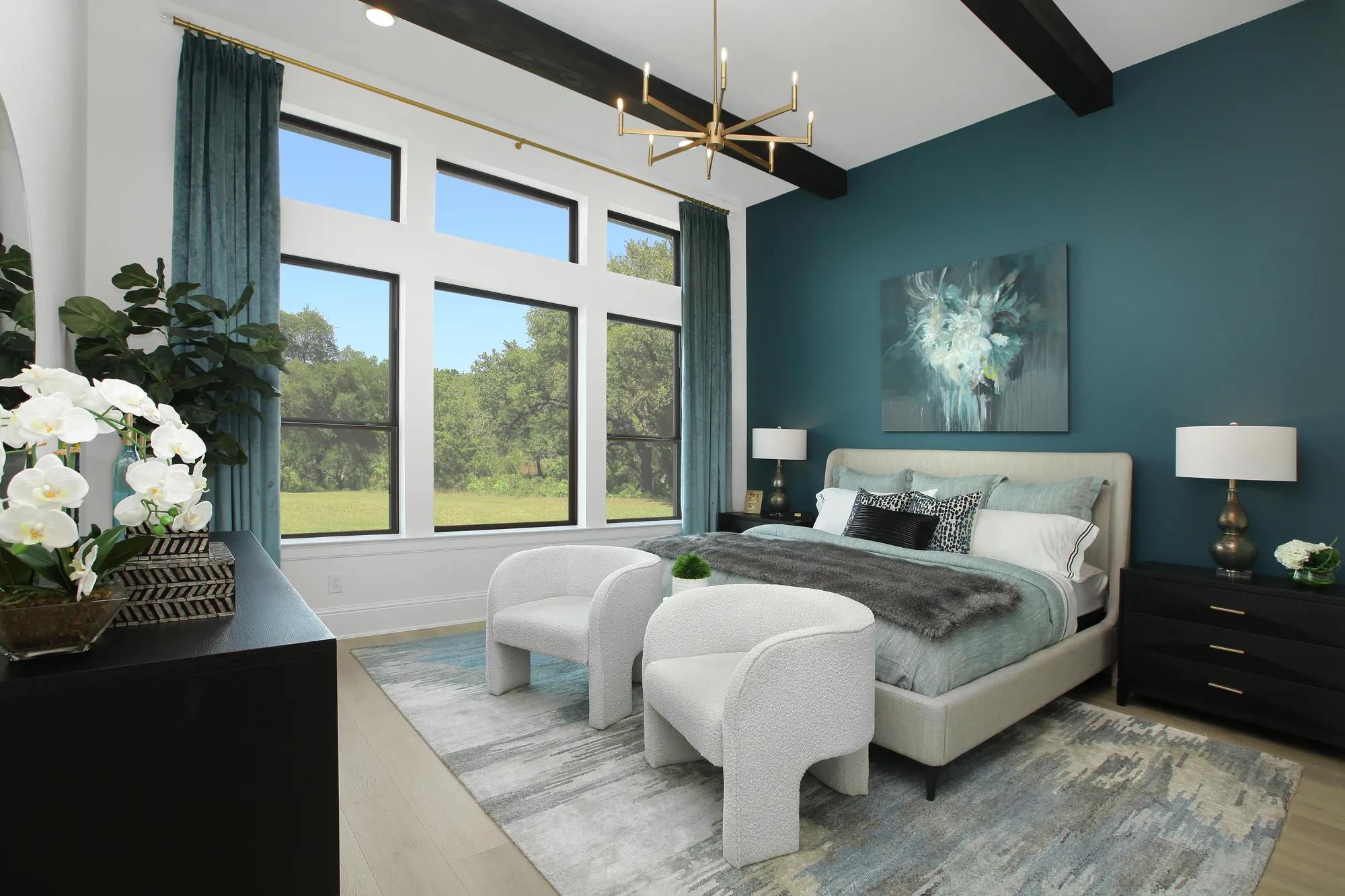 Custom home primary suite with wood beam ceiling and teal and gold accents 