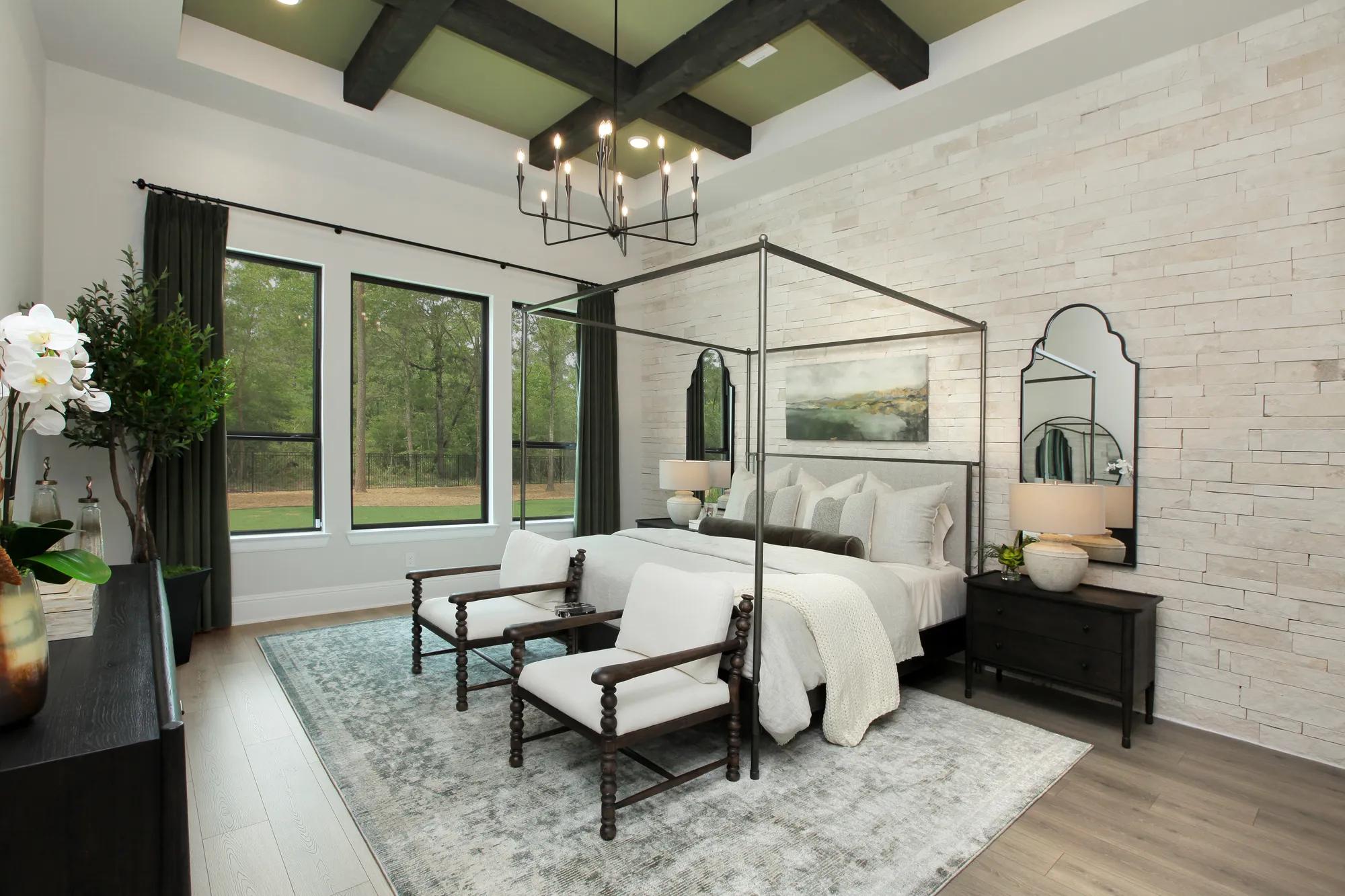 Custom home primary suite bedroom with stone accent wall