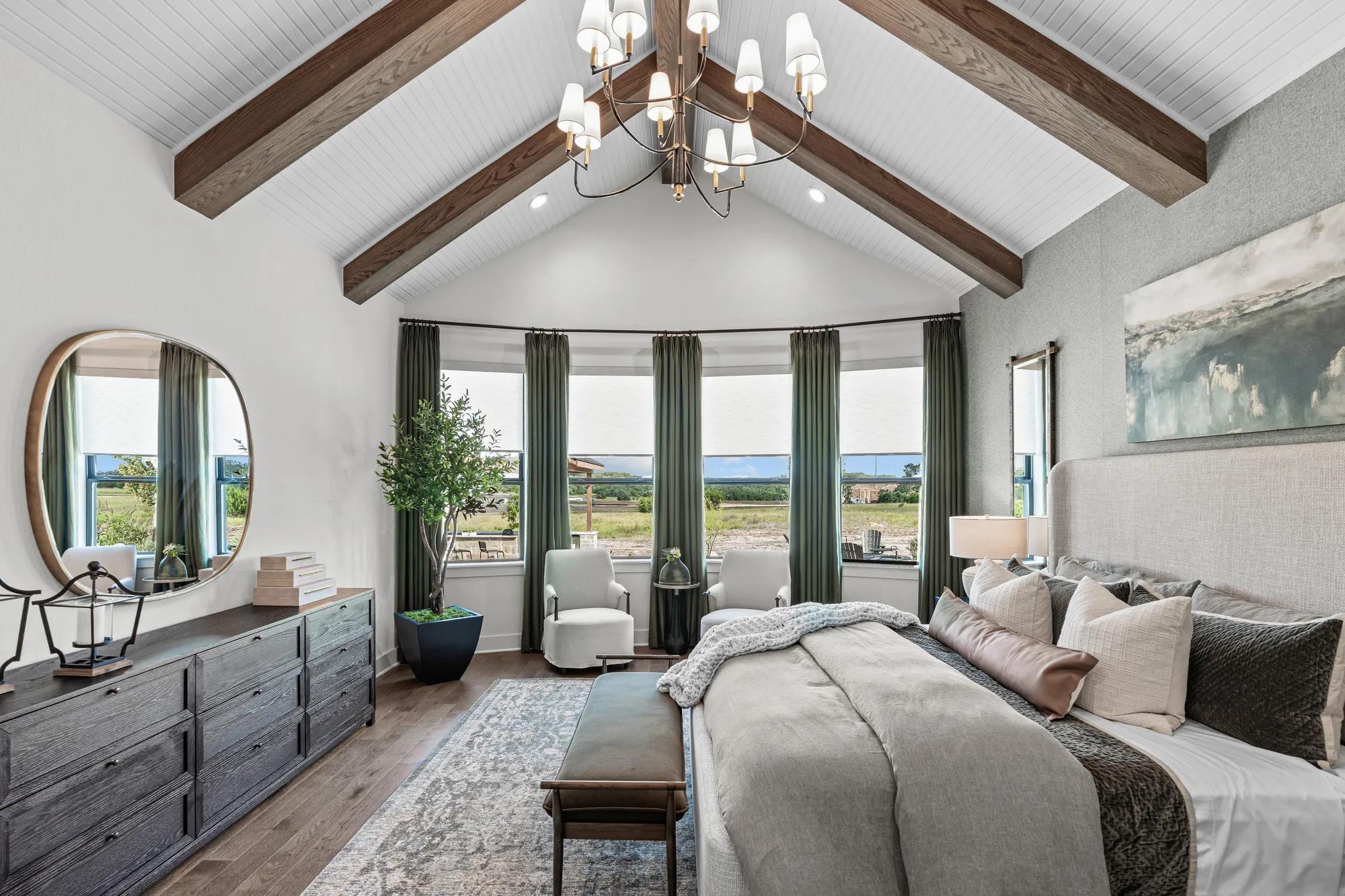new home primary bedroom with window wall, hardwood floors and barrel-vaulted ceilings