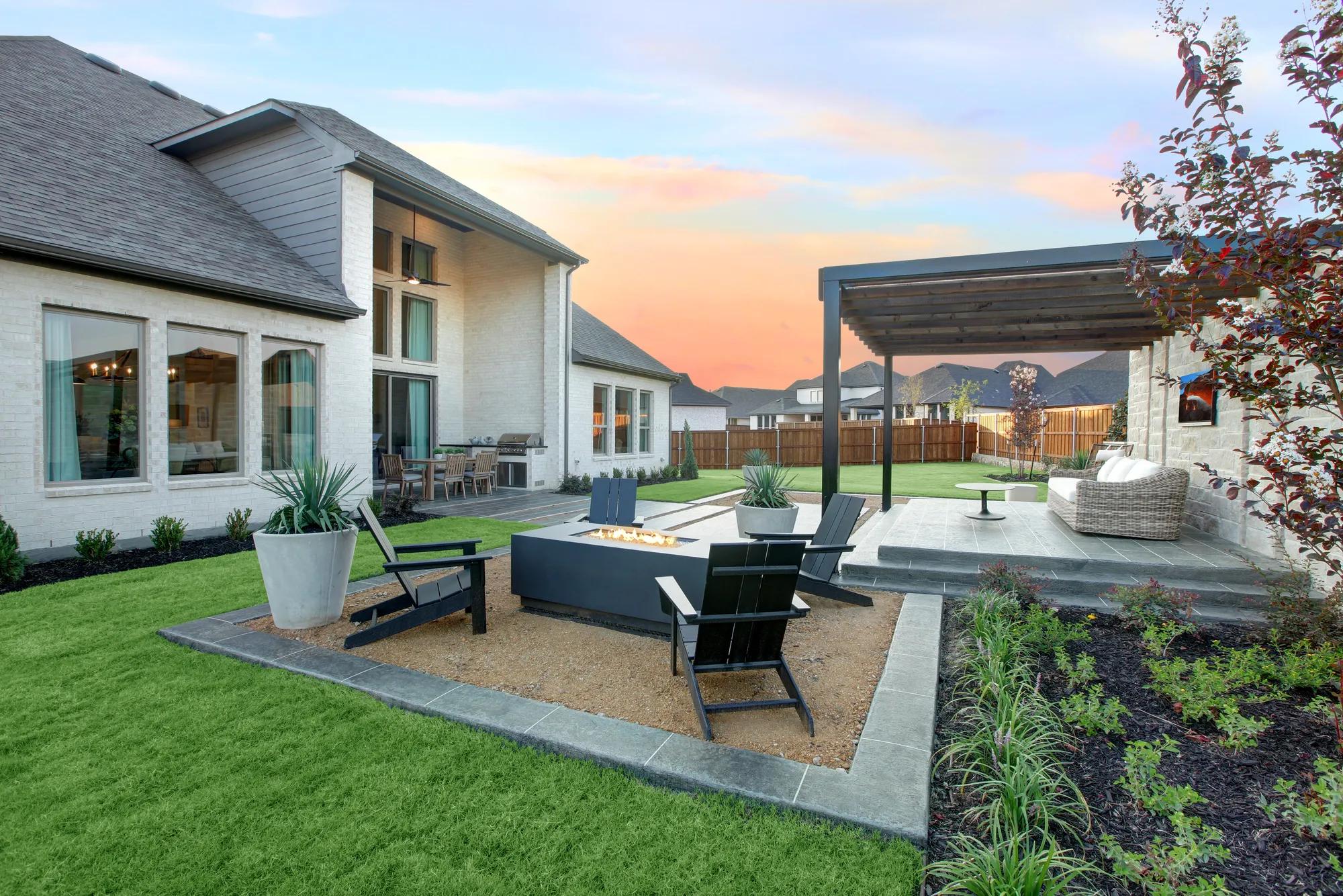 Custom home backyard outdoor living area with pergola, firepit and covered patio