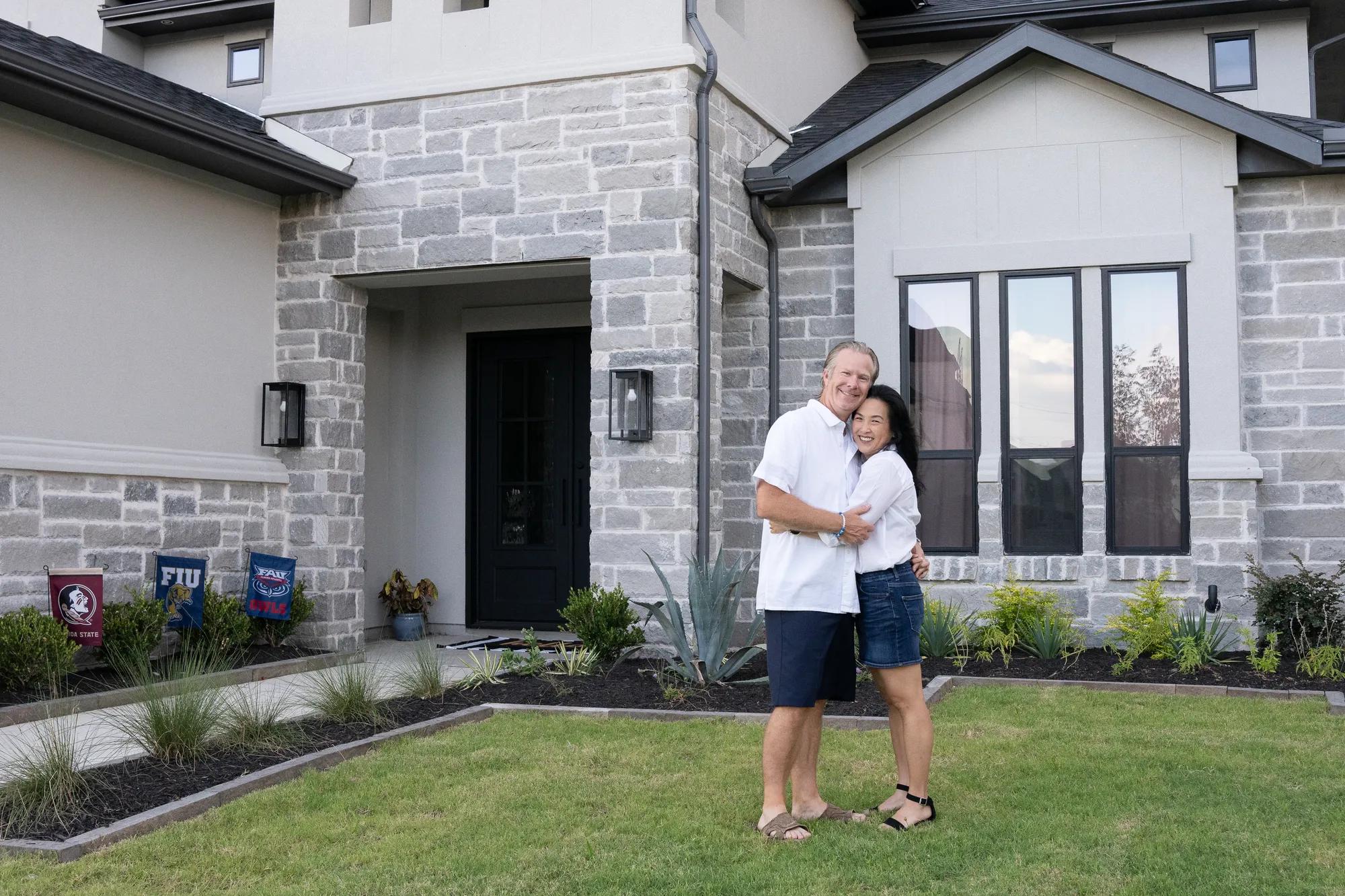 New homeowners enjoying the beautiful front yard of their gorgeous Lynmar style home