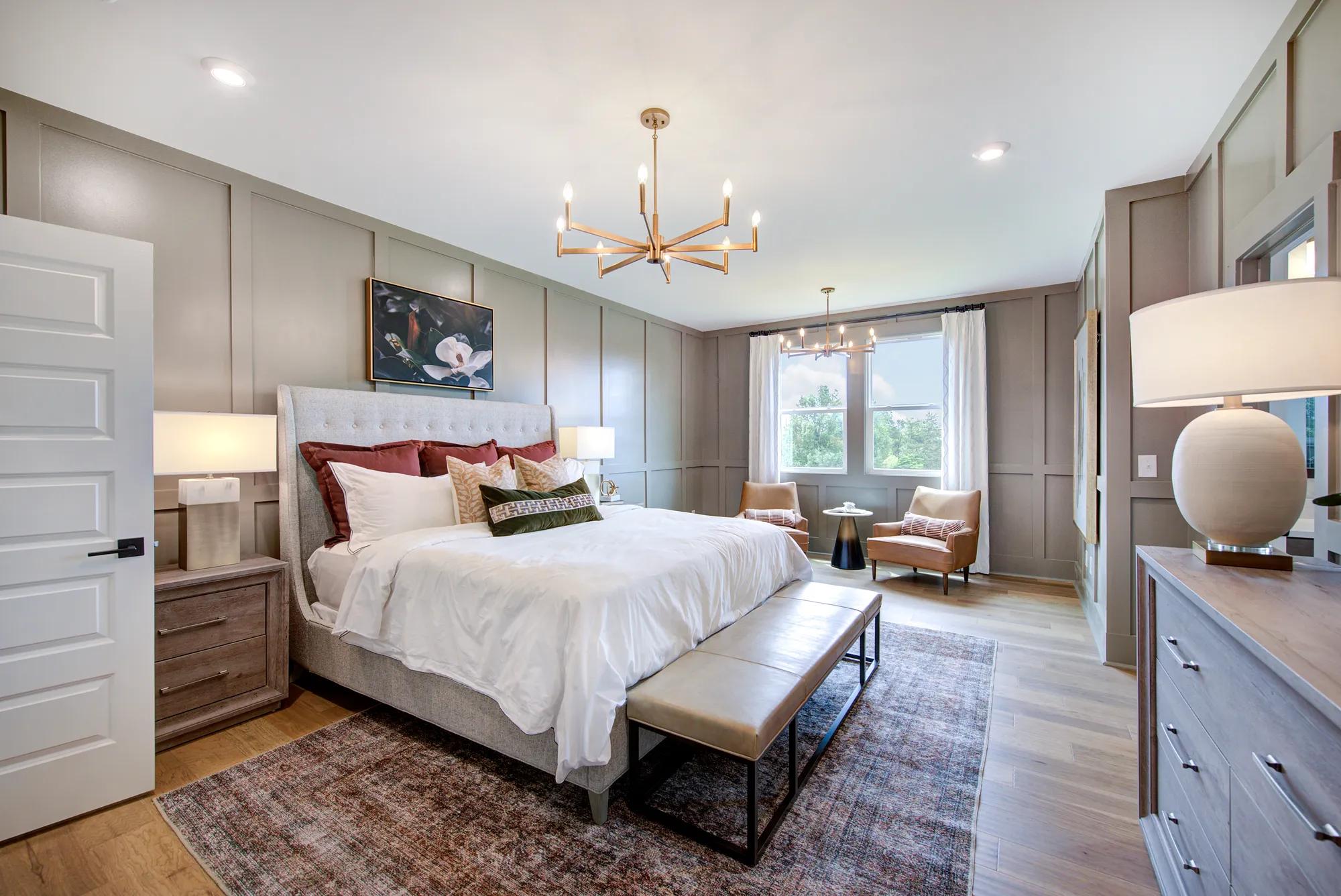 New home primary suite with luxury vinyl tile floors and chandelier lighting