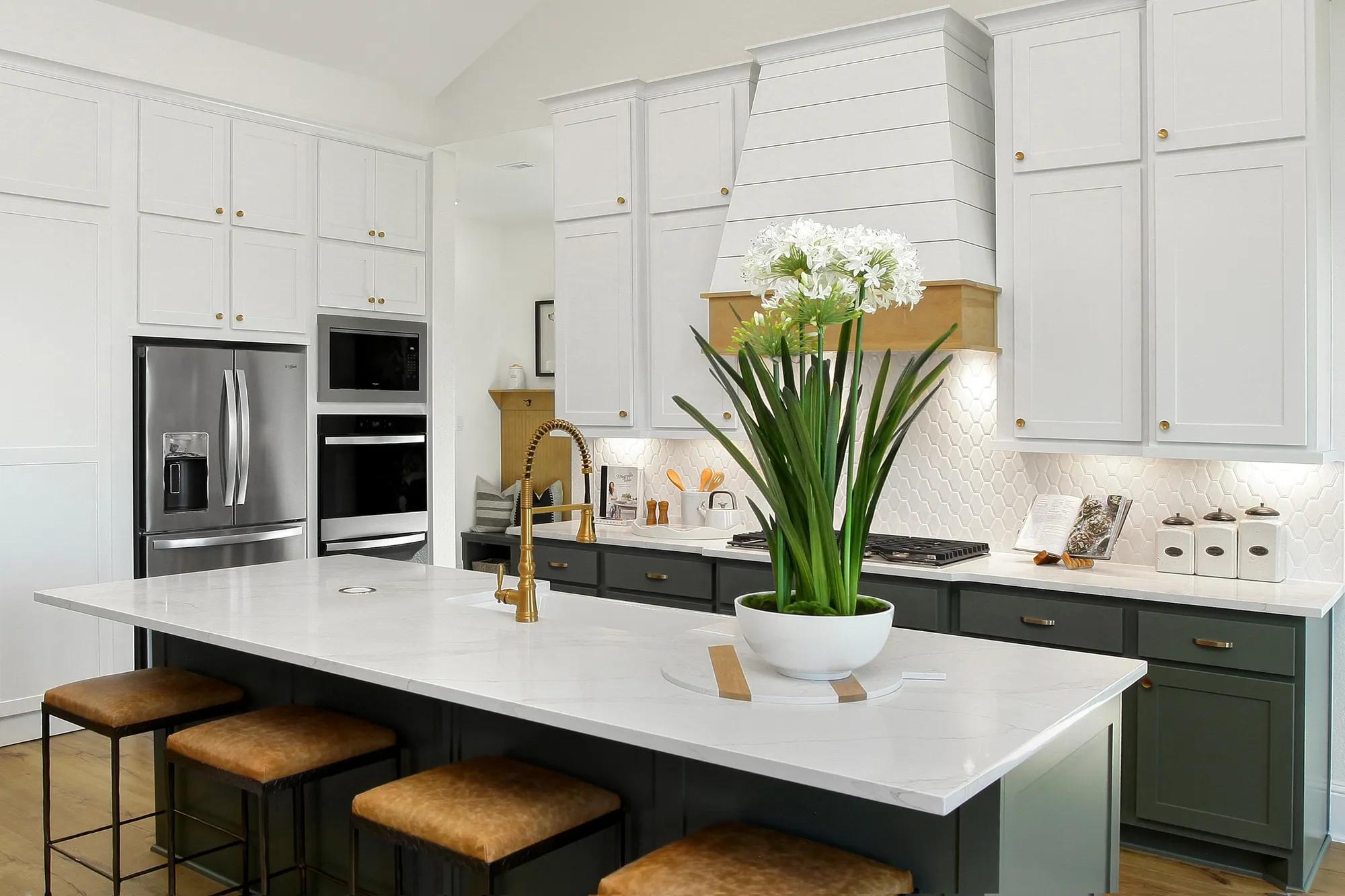 Custom home kitchen with white cabinets and contrasting green lower cabinets and kitchen island 