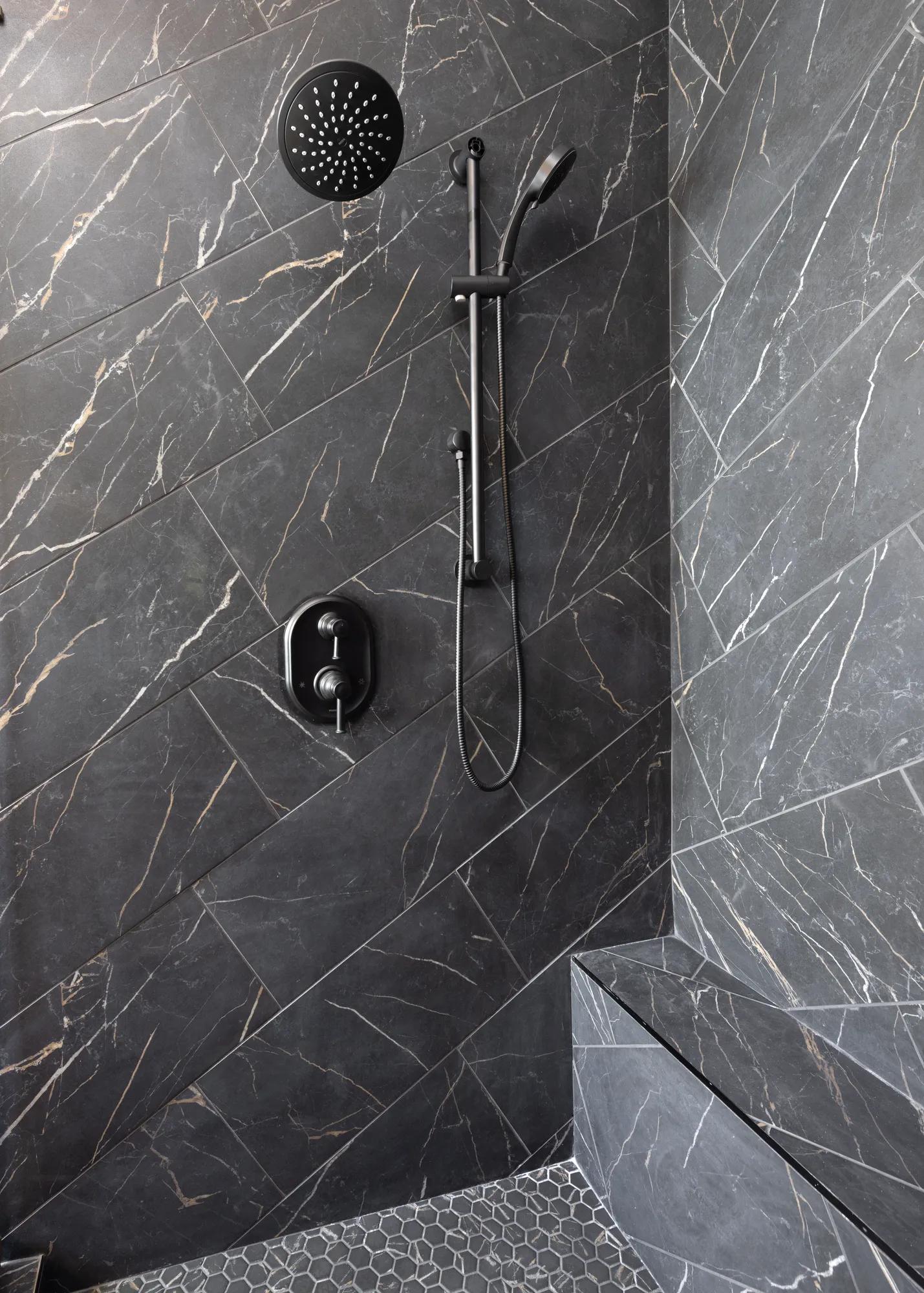 Custom home primary bathroom with modern black tile shower