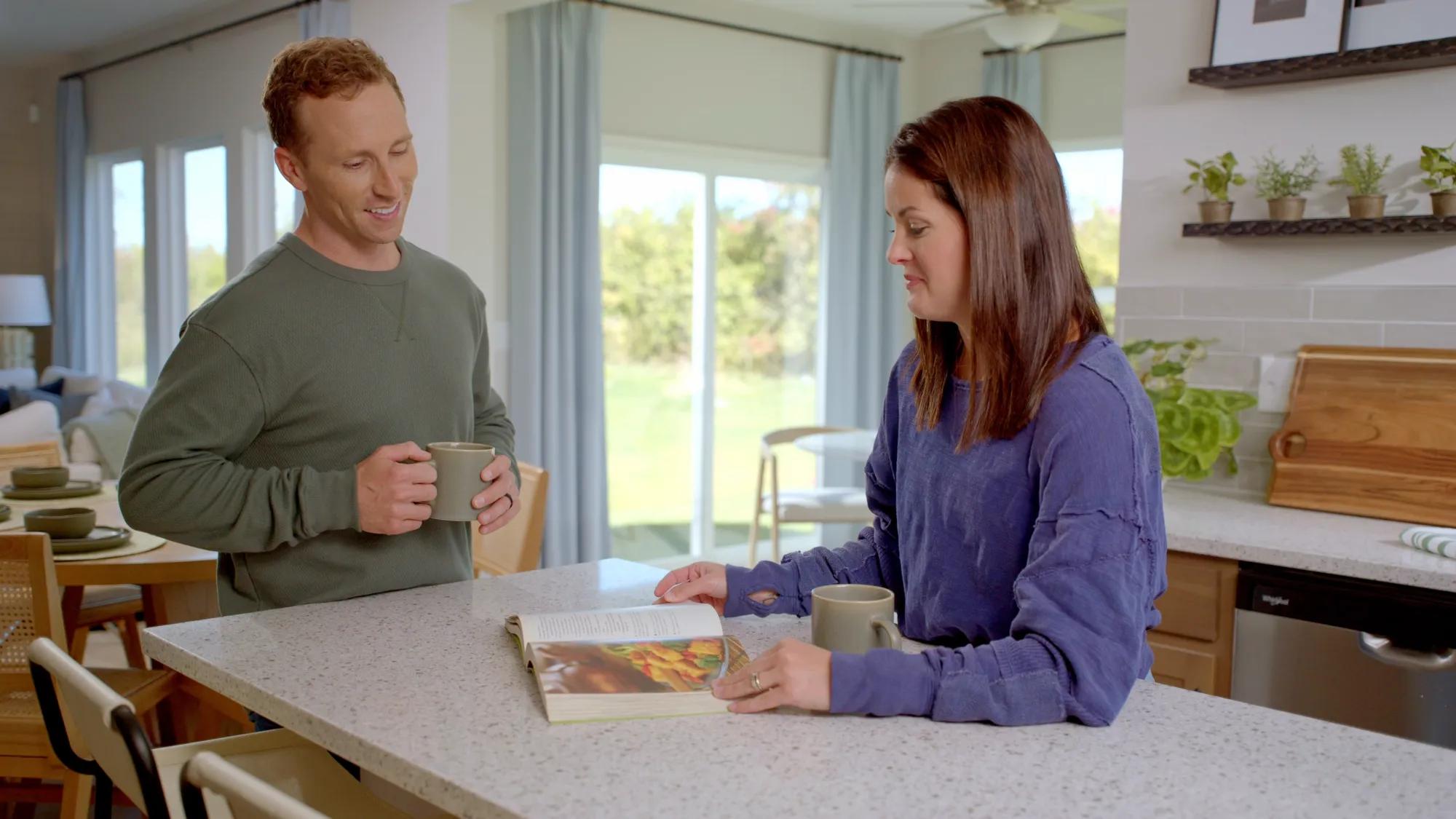 Couple talking at kitchen island over coffee