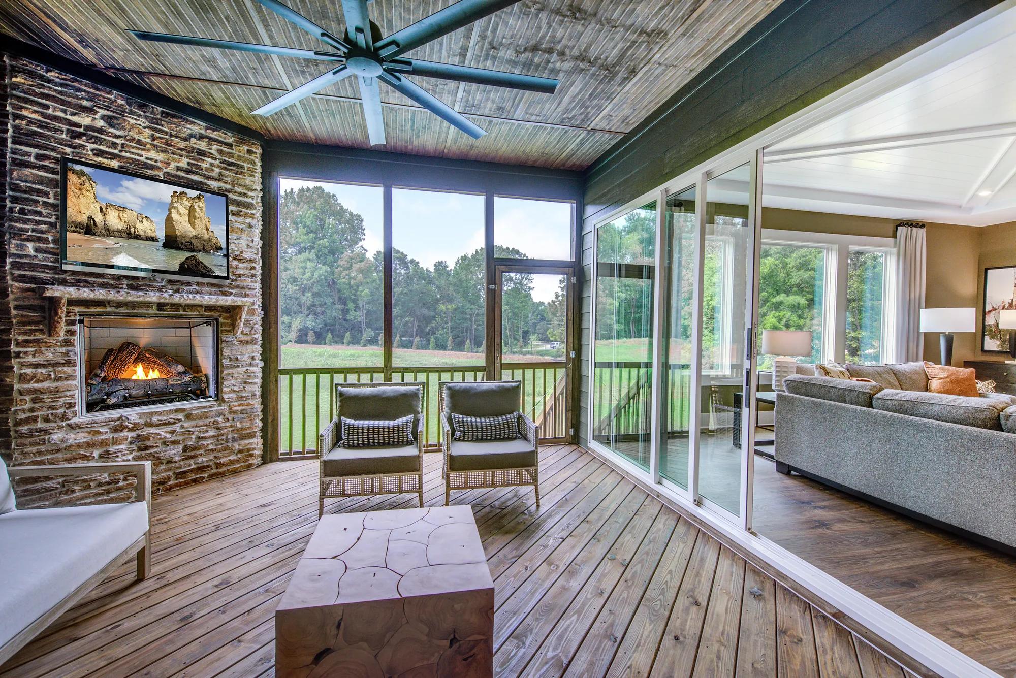 Custom home screen porch with stone fireplace and sliding glass doors to living room