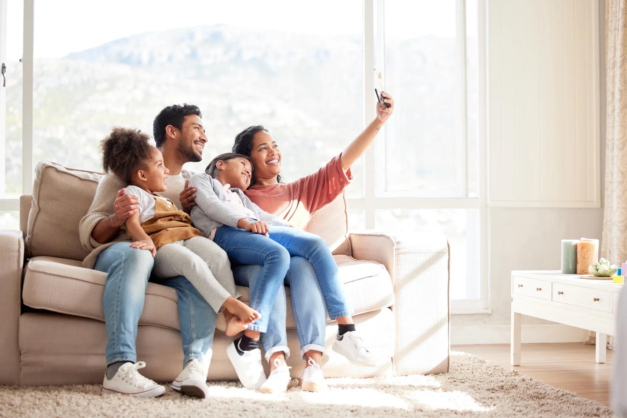 Family taking a photo in their new home living room